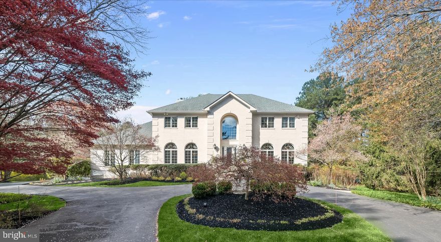 METICULOUS & PRISTINE HOME IN CLARKSVILLE, MD
Stunning and supremely private, this luxury residence is perfectly situated on over three beautiful acres surrounded by trees.  Experiential outdoor living features include a low-maintenance composite rear dining deck and gazebo, flowering trees, garden beds, and meticulously manicured landscaping that together create a beautiful and serene setting.  In front, a private entry and circular drive are followed by a storied covered porch and foundation plantings to celebrate arrival for invited guests.   Pristine inside and out, the exterior boasts all white brick on four sides and is accented with quoin corners and a dramatic arch entry sided by arched windows on the front elevation.
Inside, exquisite interior spaces invite luxury living and grand scale entertaining beginning with the elegant two-story foyer with marble floors and circular stairs sided by living and dining formals with accent molding and hardwood floors.  The grand foyer and the extended foyer unfold to a back hall and central family room with a sweeping, oversized picture window framing views of flowering trees and stunning garden beds.  The spacious family room features a large wood burning brick fireplace and an oversized cased opening into the kitchen.  Perfect for entertaining, a fully upgraded gourmet kitchen connects to the formal dining room and to an informal breakfast room with slider door leading to a dining deck and gazebo to the on the other side. 
At center stage, a commanding contrasting wood island is enhanced with turned legs, a breakfast bar, and a pair of pendants above.  Fresh white cabinetry wraps the kitchen perimeter, outfitted with pullouts in every cabinet, while a sparkling white quartz counter is accented with an up-to-the-minute designer backsplash and under cabinet lighting. This Chef’s kitchen offers a sink on the island, secondary prep sink in the corner, a paneled Sub-zero fridge, Wolf gas wall oven, convection microwave, and Wolf gas cook top station. The Kitchen-aid beverage fridge is conveniently situated to service the kitchen, family room, breakfast area, and deck.  The main level is completed by a study with hardwood floors and an adjacent powder bath.
Upstairs, the central landing overlooks a dramatic open curved stair with a plush carpet runner. French doors open into the spacious owner’s suite featuring decorative ceiling moldings, a large walk-in dressing closet with ample space for two wardrobes, and a two-sided gas fireplace in the sitting area. The suite has a fully upgraded spa-like bath with a gas fireplace, jetted-tub in the center, extended double vanity, walk-in shower, water closet and double linen storage closet. The upper level is completed by three bedrooms and two additional full baths.
Downstairs, there is full daylight streaming through windows, a slider door, and a private side entrance.  This incredible lower level can have a completely private entry accessed by its own door and sidewalk. A full bath and four rooms along the rear offer full daylight and could be used for private business offices, Au-pair, or in-law suite living. The lower level is completed by a workshop and secondary bath rough in.  The flexibility and lifestyle options are simply endless.  Come home to a serene setting with gorgeous upgrades and endless flexibility for living working and playing at home!