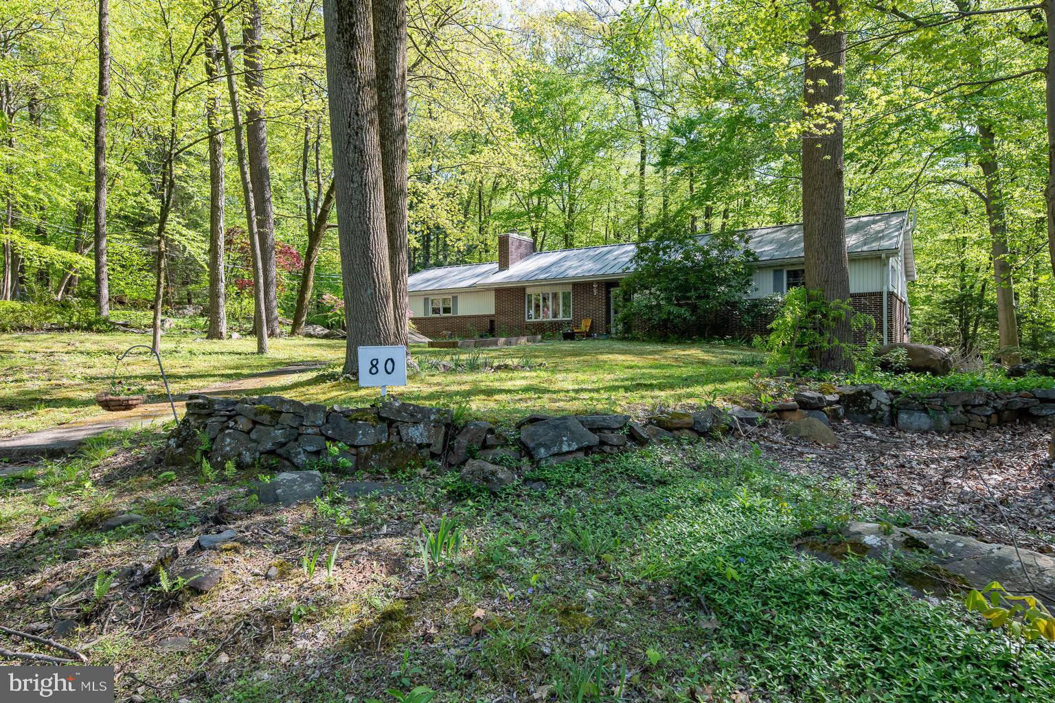 Nestled in a Private 2.66 Acre Wooded Lot in the far corner of Spring Ford School District situates the Perfect 3 Bedroom, 2 Bathroom Custom Ranch Home. Enjoy the setting from your front patio overlooking the mature landscape, gardening areas,  and open front yard for play.  The oversized 2 car attached garage,  1 car detached craftsmen garage, provide many options for the hobbyist, collector, or growing family. The garage provides access points into home as well as into the walk-out basement; which features a brick fireplace, natural light, plumbing infrastructure, and just so much potential to refinish the large clean footprint.  Entering the home from the garage area you will be charmed by the gracious eat-in kitchen/dining room combination featuring  oak cabinets, wainscoting, built-in microwave, and double sink overlooking the wooded rear lot, large walk-in pantry with main floor laundry set up. Offset is the comforting 15x15 sunroom on the rear of the home. This space is serine with natural night, observing the natural wooded rear landscape, with cathedral ceilings, inset skylights, natural wood interior, and tile flooring. The family room features brick fireplace with wood stove insert, built-in shelves, and a large bay window. The master bedroom is situated in the far rear corner of the home with a large walk-in closet, great natural light outlooking the lot, and a nice private bathroom. Both additional bedrooms have spacious closets and are complimented by the large hallway bathroom with shower/tub and tile flooring. Rest easy at night knowing the expensive infrastructure work has been complete by the homeowners, including new septic, 2014; well pump 2015, steel roof 2015, HVAC 2019, and so much more. Seemly, you are in a wooded oasis, but this location is conveniently located 422, Rt 100, Rt 73, very local Ridge Pike village commercial locations.