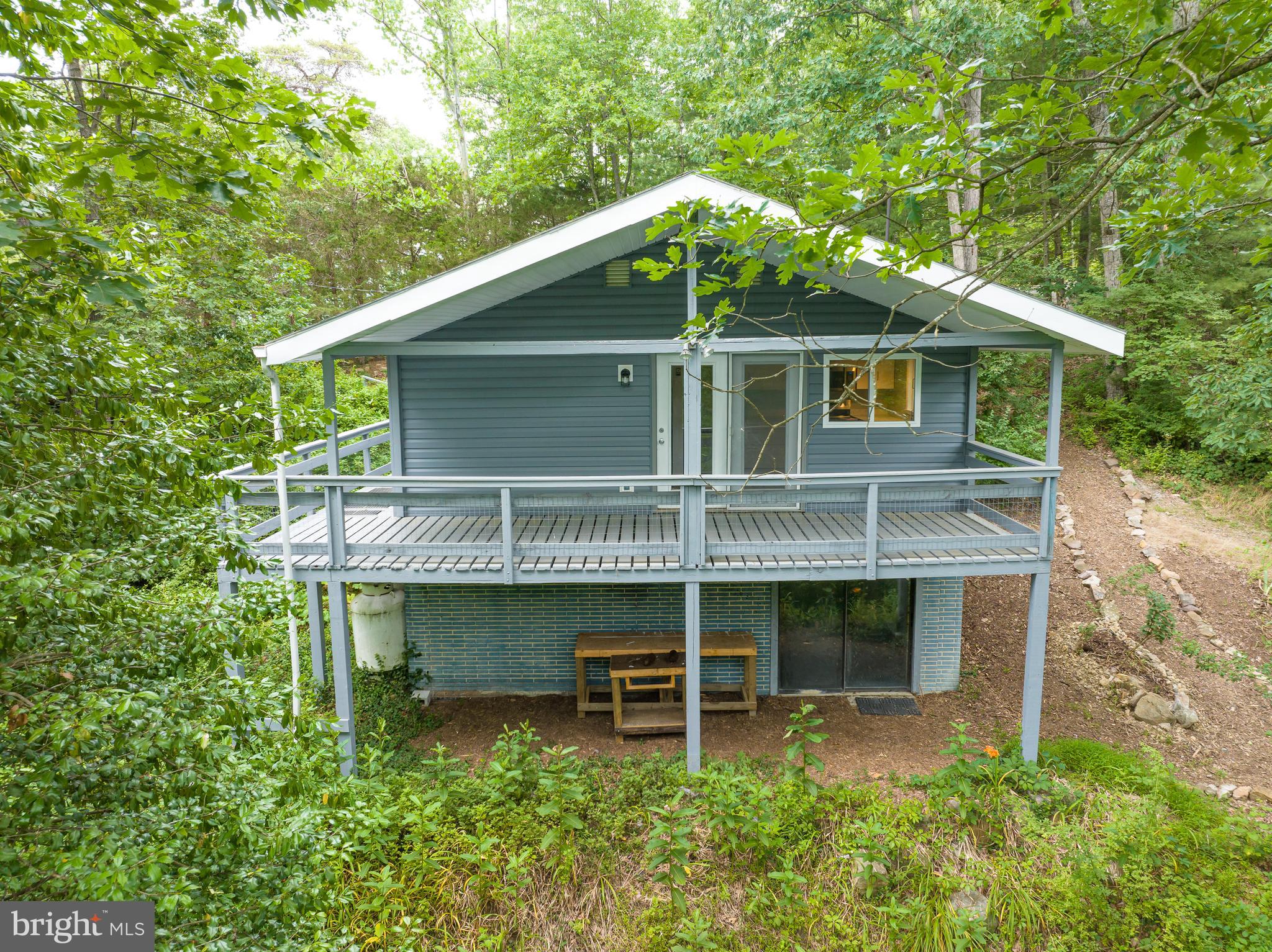 This lovely 3 bedroom 1 bath rancher has been updated throughout! Improvements include new siding, updated windows, and a freshly painted interior. A slightly inclined ramp leads you from the driveway to your side deck and your front porch. Inside the spacious living room features laminate floors and a propane wall heater. There is lovely ceiling height built-in bookshelf. The track lighting is accented by the vaulted ceiling. The living room is open to the kitchen. Kitchen features updated cabinets and new laminate countertops. Flooring is LVT. All appliances have been updated to stainless steel. There is new track lighting above the sink and an updated, decorative light fixture. Glass doors lead out to the large, covered deck. Bedrooms 1 and 2 are generously sized with laminate flooring and plenty of closet space. The hall bath includes new, LVT floors, a single bowl vanity and 5 ft acrylic tub/shower. There is a large closet right outside that could be used for main level laundry if desired. The lower level of the home has been partially finished. There are painted concrete floors throughout. The large rec room includes a propane wall heater. The office features overhead lighting, built-in and lots of closet space. Bedroom 3 includes a large closet and glass doors to the covered outdoor sitting area. A stone lined trail leads you to my favorite spot on the property - a private fishpond! If that isn't picturesque, I'm not sure what is! Your acre lot is lush with greenery and mature trees. No shortage of privacy here! This home has so much to offer! Call for your showing now!