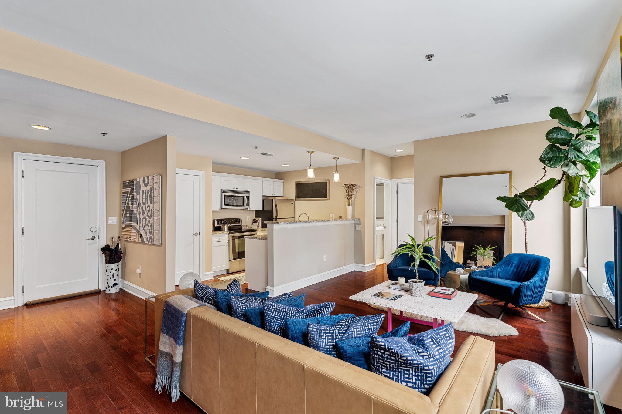 Welcome to Unit 405 at The Belgravia in Rittenhouse Square. This ideal split floor plan features two bedroom suites, one at each end of the unit, with an open living room, dining room, and kitchen. Enter through the foyer into a spacious living room and dining area, featuring hardwood floors, oversized windows, and stunning city views. The open kitchen boasts ample cabinetry and counter space, featuring a large island that accommodates prepping, entertaining, and dining. Just off the main room is a conveniently located powder room. The east side bedroom suite features an ensuite bathroom with marble tile, a glass-enclosed shower, and a single vanity sink. The west side bedroom suite is also en-suite; this bathroom features a bathtub/shower, single vanity sink, and a washer/dryer closet. A small balcony can be accessed through the dining area. The Belgravia is a centrally located elevator building with 24/7 front desk staff and a fitness center. Situated in the heart of Rittenhouse Square, with the best restaurants and retail just outside your door.