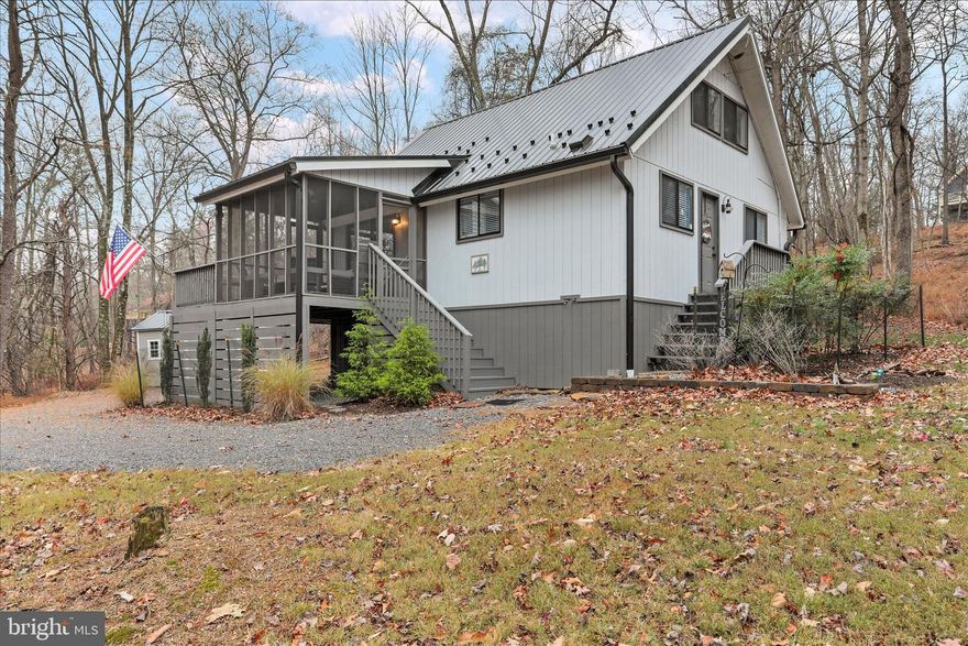 Mighty Little Elmwood Chalet
104 Blizzard Lane | The Woods, WV

Small in footprint but grand in spirit, this fully renovated Elmwood model chalet captures everything beloved about mountain living in The Woods—vaulted ceilings, a dramatic wall of windows, and effortless connection to nature.

Originally constructed in 1985, the home was rebuilt in 2020, with every major system replaced: all new electrical and plumbing, complete kitchen and bath renovations, new flooring, paint, appliances, and a durable metal roof. The exterior received the same thoughtful attention with fresh paint, updated hardscaping, and any suspect materials replaced.

Inside, you’ll find luxury vinyl plank flooring throughout, soaring ceilings, and an airy open layout that lives larger than its size. The loft includes a closet, making it suitable as a second bedroom, home office, or creative space—bringing the total living area just shy of 950 square feet.

Ongoing improvements include a matching storage shed, new interior hardware, lighting, and ceiling fans, replacement of the majority of decking with fresh paint to all exterior decks and stairways, and an expanded gravel driveway with a new culvert.

Set on 1.09 acres of woods and lawn, this home combines the warmth of a neighborhood setting with the tranquility of nature. It has been carefully maintained inside and out, with regular professional servicing to keep every system running smoothly.

Nestled within The Woods community, 104 Blizzard Lane offers the perfect blend of charm, quality, and low-maintenance living—a true “small but mighty” escape.
