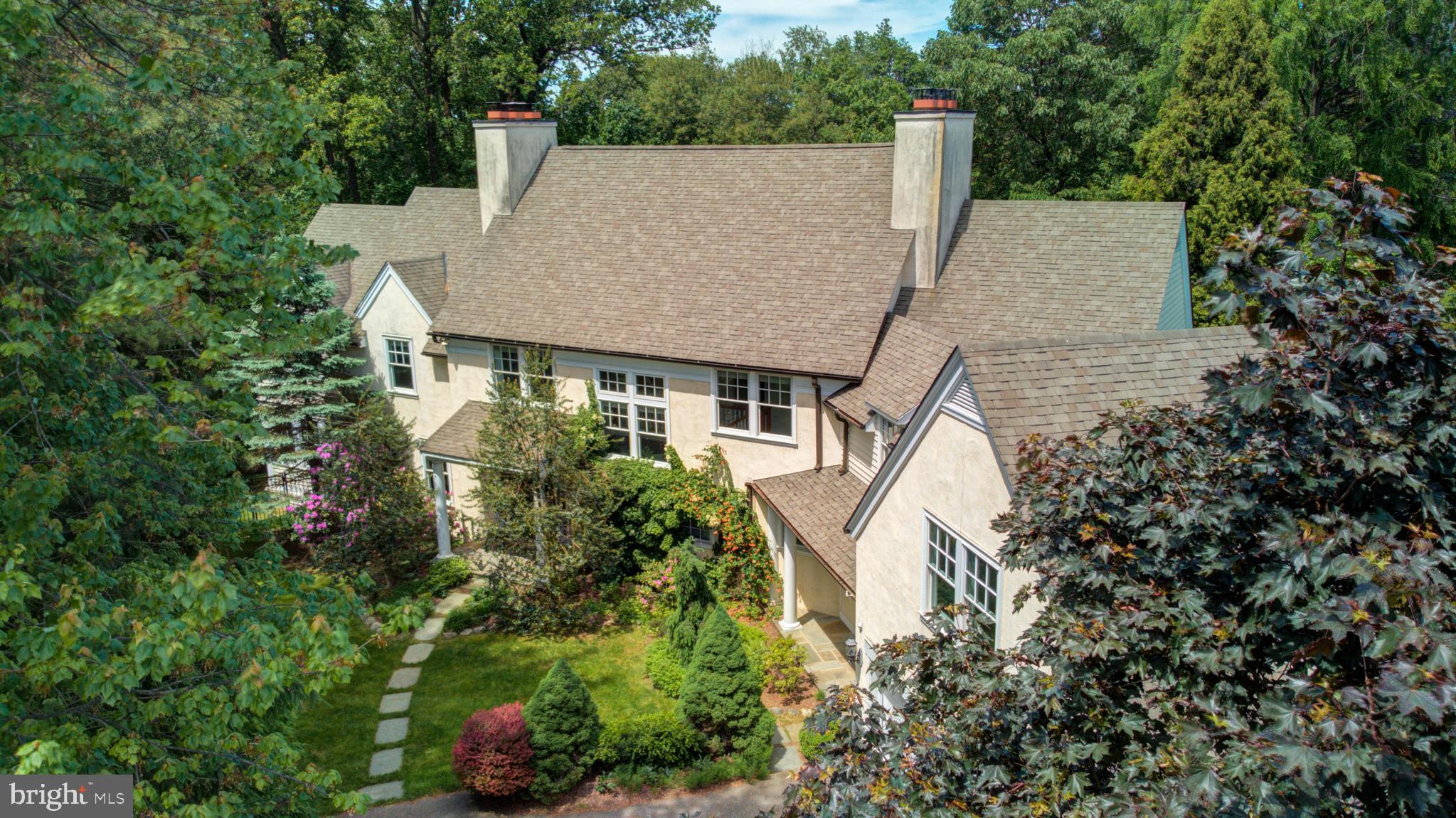 On one of the most exclusive roads bordering the Wissahickon Valley sits this well appointed newer home with all modern amenities. Designed by a local architect, this home was thoughtfully built on this full acre+ of land to enhance and maximize its exposures to the wooded area it borders. Notice the fruit orchard and mature specimen plantings as you turn into the driveway. Upon entering, you can feel the sense of proportion is just right for contemporary living. At one end of the house is an enclosed porch with three exposures, giving you the feeling of being surrounded by peaceful nature. French doors lead you to an inviting living room with a working fireplace and built in bookshelves. The formal dining room entrance is framed by columns as a nod to the architecture of the older mansions in the area. The cooks kitchen features a 6 burner professional grade stove with a double oven, an extravagant amount of counter space and more than ample cabinet storage. There is a lavishly sunny spot for in-kitchen dining. The adjacent nook is the perfect spot for a housing a bar and glassware, grab a glass as you step out onto the adjacent patio! From the kitchen, you'll have full view over the family room, with a bar height counter in between. The television is integrated inside the cabinets underneath the counter, another thoughtful detail. Step out the family room doors right onto the pool patio with a luxuriously sized in-ground pool, with evergreen trees along the patio's border so there's never a leaf to scoop! The salinated pool has been diligently professionally maintained and has been upgraded through the sellers ownership. A sonos sound system with external built in speakers will make outdoor/ indoor living seamless. On the upper level, a master suite with soaring vaulted ceilings boasts double closets. The adjacent new marble bath is generously sized with double sinks and beautiful fixtures. The second and third bedrooms are comfortably sized and share a jack and jill full bath. There is abundant storage for linens and such in the bathrooms as well as in closets along the hallway. A dedicated laundry room is also on this level- no need to take laundry to the basement! Continue down the hall to a beautiful bedroom with built-in bookshelves that has a gorgeous and updated full-bath. At the end of the hall lies a huge bedroom with vaulted ceilings, mirroring the master bedroom, that can also be used as a studio or giant office space. A clean and dry carpeted finished basement with a bounty of storage complete the interior of this home. This home has 3 zones of central heating and A/C and pro-active owners who made sure everything was well maintained. Attached 2-car garage with direct entrance to interior. The house has been pre-inspected and corrections and repairs have been made in response prior to the listing. This house offers every comfort you could imagine for contemporary living in a secluded and bucolic setting. This one is a must-see!