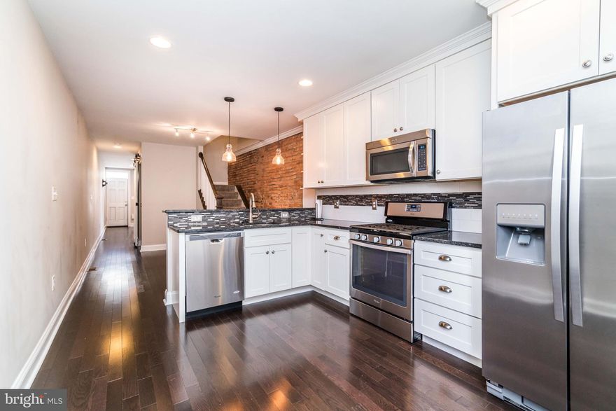 Looking for a home that has it all? Well then welcome home to 127 W. Randall St, because this property has it! Enter in to your spacious living room filled with gorgeous hardwood floors, beaming with natural light. As you continue to walk through the home, you are immediately filled with modern meets rustic vibes - a sliding barn door that separates the living room from the basement. Enjoy an over-sized and STUNNING kitchen/dining room combo featuring granite counter-tops, breakfast bar, tons of cabinets and exposed brick. A convenient door to the exterior rear courtyard is perfect for entertaining and grilling right off of your kitchen, along with a half bath on the main level for you and your guests. As you walk upstairs you are greeted with two master suites both with beautiful bathrooms and spacious closets. Looking for a rooftop deck? GREAT! Enjoy your new rooftop deck with city and stadium views perfect for watching fireworks on the holidays and enjoying cocktails during sunsets. The basement features a second living room which could be a third bedroom with a beautiful full bathroom and built-in vanity. Optional private parking garage for rent 1/2 block away makes for easy parking! Enjoy the luxury of city life while on a quiet street yet only blocks away from the M&T/Camden Yards stadiums. This home won't last long! Schedule your private showing today! *$120 processing fee if approved. Pets allowed on a case by case basis.