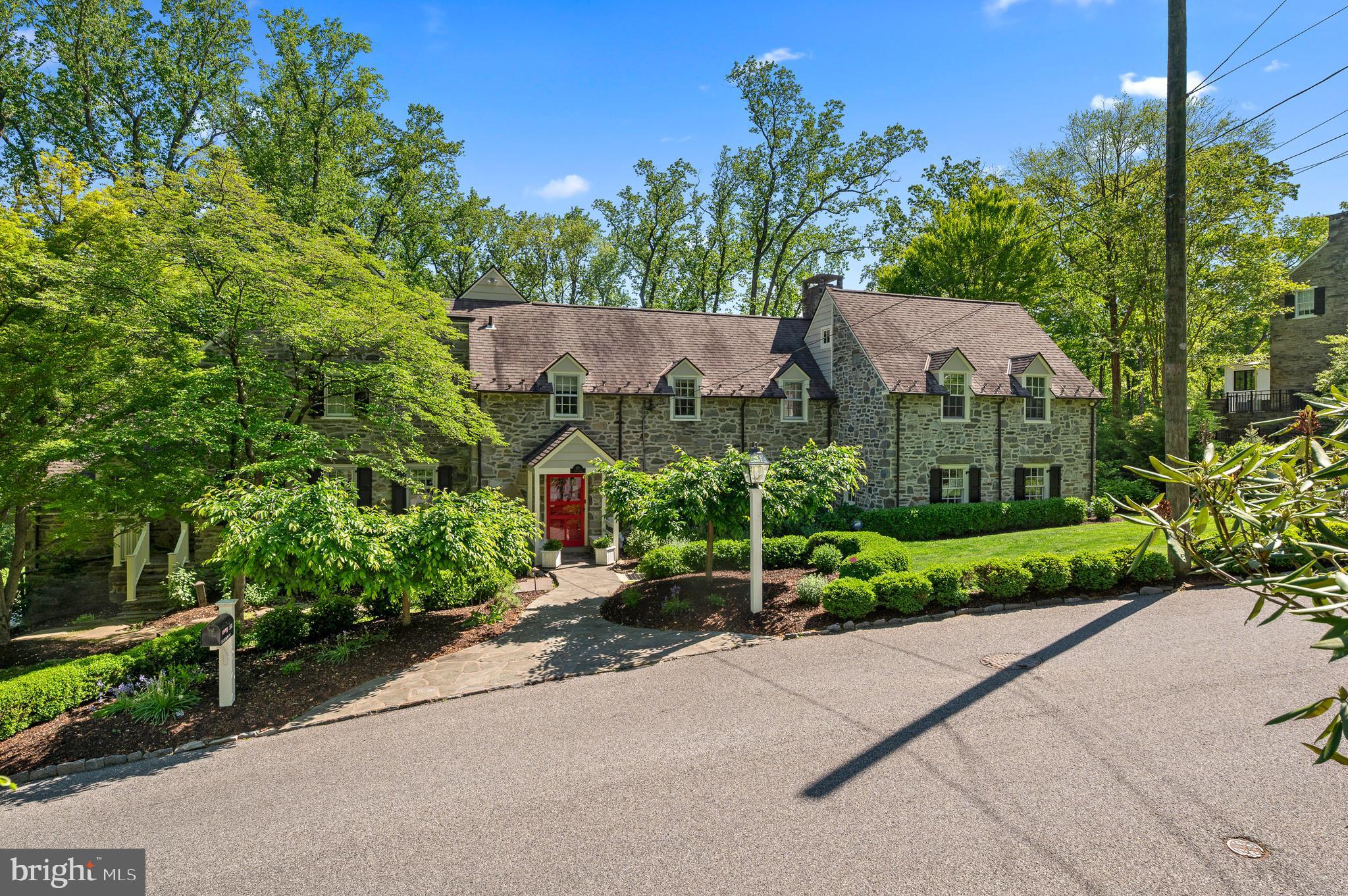 Main Line treasure. Perched elegantly on one of North Haverford’s most sought after streets, this quintessential fieldstone colonial is the very first home built by renowned builder/architect Walter Durham in 1925. Durham’s homes were known for ‘the light coming in and the views looking out’; this home captures both exquisitely. The gracious street presence is complemented in the back by oversized windows with tiered garden views; french doors to flagstone terrace as well as sun porch and deck overlooking the stunning landscaping. Inside, the original home was reimagined with a complete renovation in 1999-2000 (Richelou builder, Lou Schneider architect) elevating the original bones and character to modern day standards. Walk through the signature covered front door entry to the charm and grace of the reception hall. Original oak floors continue from the entry through the formal living and dining spaces. The dining room overlooks the majestic yard and leads to the sun porch and onward to the terrace. The living room is finished with an oversized fireplace, built-in shelves and french doors to the terrace. Through the dining room, an expanded chef’s kitchen features cherry cabinets, stainless steel appliances, honed granite countertops, oversized island, eat-in dining space with windows on three sides and walk out to a deck, ideal for grilling. Pocket doors lead to a family room immediately off the kitchen, which also opens out to the deck. A laundry room, full bath and mudroom off the kitchen give this expansive family space every convenience but is nicely tucked out of view of the kitchen. The true gathering space is a much larger family room with exposed stone, painted beams, triple exposure windows, radiant heat and french doors to the flagstone terrace. Upstairs, an expansive master suite boasts a fireplace, ample closets, lounge area with exposed stone and large windows overlooking the backyard. A luxurious master bath is finished with Carrera marble and features a deep soaking tub with deck, double vanity, glass shower and radiant floors. Continuing on the second floor, two additional bedrooms share a jack/jill bathroom and a fourth bedroom has an attached bathroom and french doors to a flat roof deck. The third floor features a large fifth bedroom with a walk-in closet. A finished basement offers additional rec/craft/gym space. Meticulously maintained with unparalleled pride of ownership. Walkable to Haverford town center, Haverford train station and Merion Cricket Club. Commuters dream with easy access to all major roadways. Lower Merion School district.