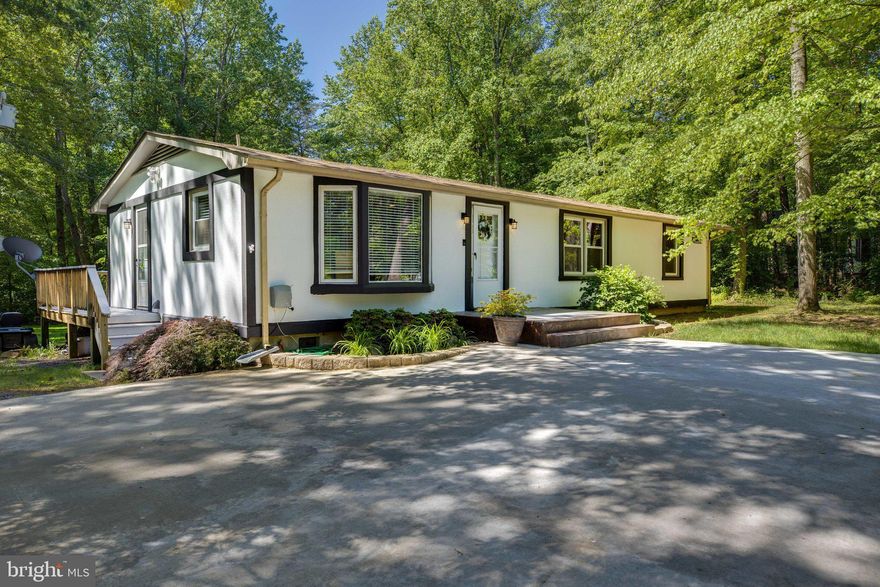 Welcome Home! No HOA. This 1+ acre property is a perfect getaway from the stresses of life. A scenic backdrop with plenty of woods, this home is waiting for you. Seated perfectly among green grasses and trees, this 3 bedroom, 2 full bath home is updated with modern touches perfect for anyone. Enjoy a large walk in closet with standing shower in the primary suite. The secondary bedrooms have ample space with large closets. Stainless steel appliances adorn the kitchen and laundry space. A wrap around deck makes entertaining and relaxing a breeze. Speaking of breezes, you'll most certainly enjoy the wonderful breeze provided by these woods. Outside, lots of hardscape plus a stone patio with built in fire pit means enjoying all that life has to offer will be made easy for you. If you love to host events for friends or family, this home is the perfect place to do it. Parking is never a problem here. The large drive space accompanies several vehicles, whether personal or business vehicles. There are pre-drawn blue prints for an extended garage space should the new buyer of this wonderful home decide to build them out.