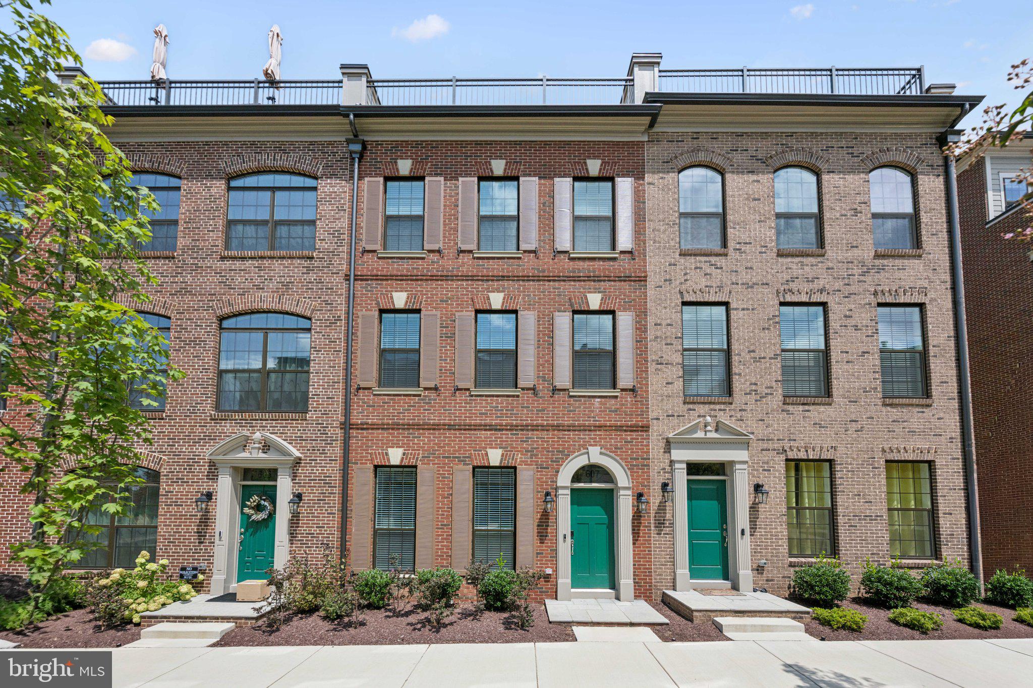 Welcome to 607 Skiff Way, a beautiful blend of understated elegance and comfort spread across a four-story townhome on a quiet block in the gated community of Potomac Overlook. If you’re looking for a place to both entertain and relax in, this home has options in spades—starting with an upstairs indoor lounge area that gives way to a private rooftop terrace. Another central focal point is a second-floor kitchen, which is anchored by a statement-making waterfall quartz slab island whose sleek continuity is complemented with modern stainless steel appliances and custom cabinetry. The open yet defined floor plan includes a light-filled dining room, a living room with gas fireplace, and a home office with farmhouse-style double-sliding doors that provide the perfect amount of privacy. Upstairs on the third floor, a guest bedroom with en-suite bathroom lies just down the hall from a sizable primary suite with a truly luxurious bathroom setup featuring a large walk-in shower with dual showerheads. Other notable moments include a bright first-floor sitting area and powder room, and a spacious additional fourth-floor bedroom. What you might not gather simply by looking at the photos is just how special the views in this particular unit are. Many of the downstairs windows look out to greenery, while the upstairs rooftop has a view of the water that dazzles at sunset. Part of what also makes this home such a catch, is the way it offers the best of everything. There’s seclusion and quiet comfort; it’s also just a short walk away from incredible restaurants and boutique shopping at National Harbor. Waterfront access to the Passenger Water Taxi offers scenic rides to Old Town Alexandria, Georgetown, and the DC Wharf, too. In addition to a two-car garage, an added convenience feature for homes in this enclave is the back gate, which is police-protected whenever there are large events downtown (think: conferences or marathons) and opened up for residents so they can avoid any kind of traffic. You’re at the center of it all with the added bonus of a private shortcut.