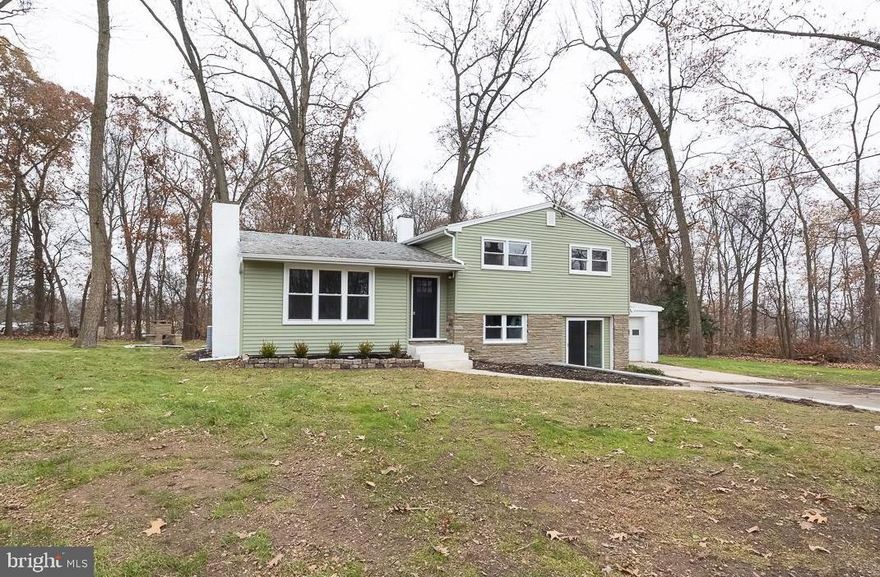 OFFER DEADLINE 7PM ON WED NOV 26. Welcome to 1050 Wayne Avenue — a beautifully remodeled home tucked away on a private .88-acre lot. Every inch of this property has been thoughtfully updated, offering modern comfort and peace of mind. Newer roof, new HVAC, new siding doors,  new windows, freshly landscaped grounds, extensive parking area, and a deep garage with workshop space. Step inside to a spacious living room featuring refinished hardwood floors, abundant natural light, and a charming brick fireplace with a coordinating hearth and mantle. The open layout flows effortlessly into the dining room, accented by a modern chandelier and views into the stunning new kitchen. Here you’ll find white shaker cabinetry, quartz countertops, a glass tile backsplash, a peninsula with seating, brand new stainless steel appliances, and a stylish farmhouse sink. Sliders off the dining room open to the private backyard, complete with an upper flagstone paver patio—perfect for outdoor dining and relaxing. Upstairs, you’ll find three generously sized bedrooms, each offering hardwood flooring, large closets, and overhead ceiling fans with lighting. The beautifully updated hall bathroom features a modern vanity, built-in shelving, tile flooring, a linen closet, and a large tile shower with a decorative niche. The finished lower level offers incredible flexibility, with a spacious living area that includes a built-in secretary desk—ideal for a home office. A full bathroom with a walk-in tile shower and tile flooring adds convenience, and the space offers potential for a fourth bedroom. Sliders lead directly outside to the extended driveway and a second paver patio featuring a built-in seating bench and chiminea. With its privacy, modern updates, multiple outdoor entertaining spaces, and close proximity to local conveniences, 1050 Wayne Avenue is move-in ready and truly stands out.