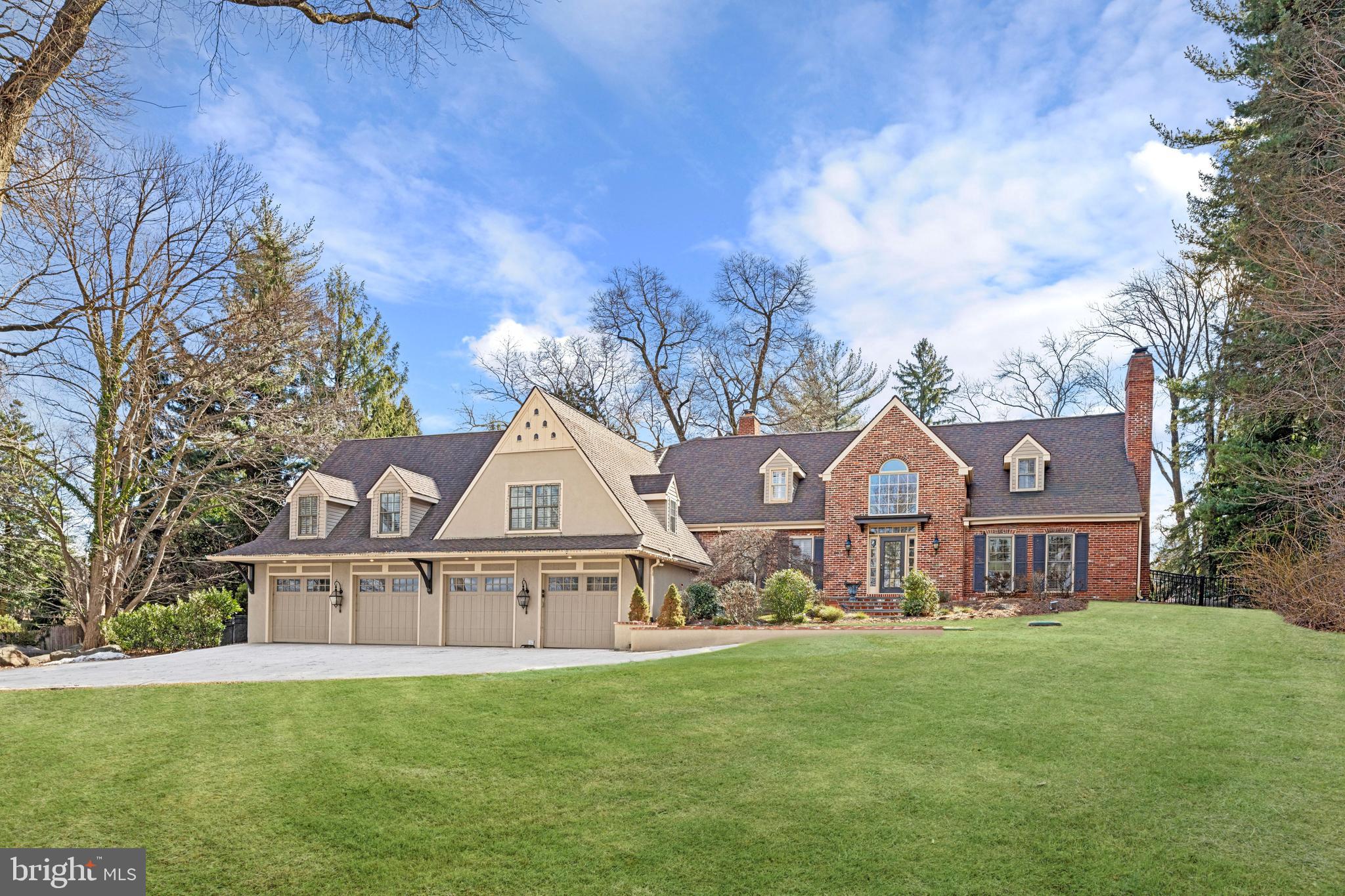 Tucked behind gates on a quiet stretch of Mount Pleasant Road, this Villanova residence offers a blend of privacy and presence. A gracious entry unfolds into a two-story foyer, its hardwood floors leading seamlessly into a living room of understated charm—two rooms with a fireplace, inviting quiet conversation or evening repose.
Beyond, a sunroom bathed in natural light extends toward the private yard, its double-sided fireplace and skylights creating a space both intimate and open. The heart of the home, a thoughtfully designed kitchen, offers an island for gathering and abundant storage, while the dining room and office complete the main level’s effortless flow. Just half a level up, a private wing holds two bedrooms, two full bathrooms, and a laundry room—perfect for guests or live-in arrangements, offering both comfort and independence.
The second floor is a retreat of peace and quiet. The primary suite, entered through double sliding doors, features a hallway with a walk-in closet and an attached bath with a double vanity, stall shower, and soaking tub. A fireplace and a sitting area create a warm, intimate ambiance, while a Juliette balcony overlooks the pool and grounds. Two additional bedrooms, each with their own bathrooms and walk-in closets, complete this level.
Below, the lower level is designed for both relaxation and lively entertaining. A family room, full bar with wine room, exercise space optional to be converted into another bedroom, and sauna offer moments of retreat and renewal. In the summer, the outdoors becomes an extension of the home—patios for sun-soaked afternoons, a sparkling pool with a dedicated pool house, and a bounce-back space to keep the games going.
With a four-car garage and ample additional parking, this home is both welcoming and accommodating. Ideally situated near major routes and the conveniences of Main Line living, it offers a sanctuary of comfort and refinement, just moments from everything you need.