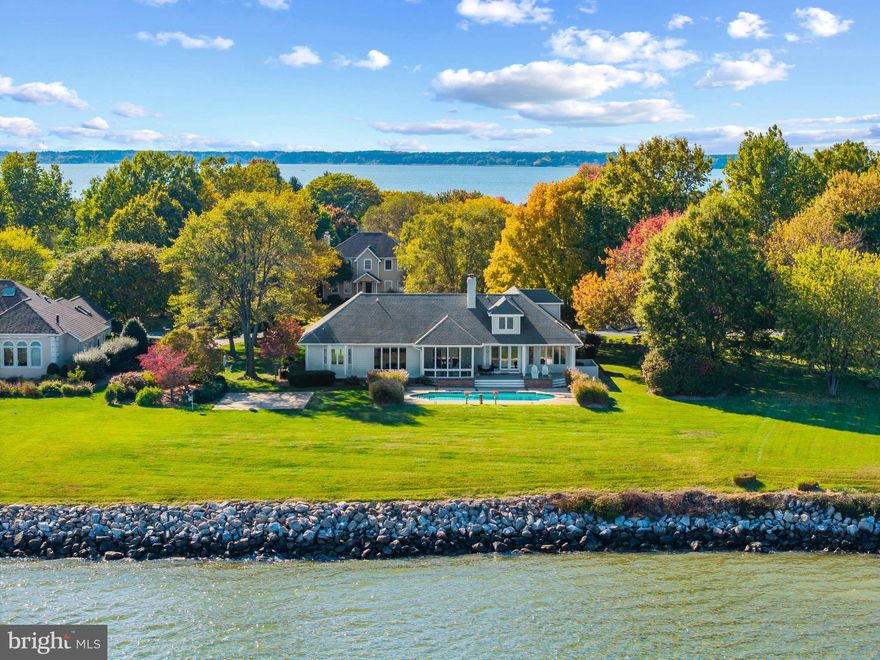 Set within Southwind, one of Kent Island’s most sought-after waterfront communities, this exceptional residence offers an elegant blend of craftsmanship and comfort with 10 foot ceilings and beautiful crown molding. Perfectly sited on an acre overlooking Crab Alley Bay and Eastern Bay, the home’s peaceful setting is enhanced by sweeping water views, mature landscaping, and a private waterside pool that invites year-round enjoyment.

Inside, timeless design meets modern refinement. The first-floor primary suite provides a serene retreat, joined by two additional guest suites on the main level—each with its own ensuite bath for privacy and comfort. Upstairs, a fourth bedroom and full bath accompany a spacious living area, ideal for extended family or guests.

The heart of the home is a stunning, renovated kitchen featuring rich finishes, premium appliances, and an open layout perfect for gathering. Gleaming hardwood floors flow throughout, leading to a mahogany-lined library that exudes warmth and sophistication—a true sanctuary for work or quiet reflection.

Outdoor living takes center stage with a screened porch that captures cooling Bay breezes and views of the pool and shimmering water beyond. Whether entertaining or simply savoring the stillness of the shoreline, every space in this home celebrates the beauty of the Chesapeake Bay lifestyle.