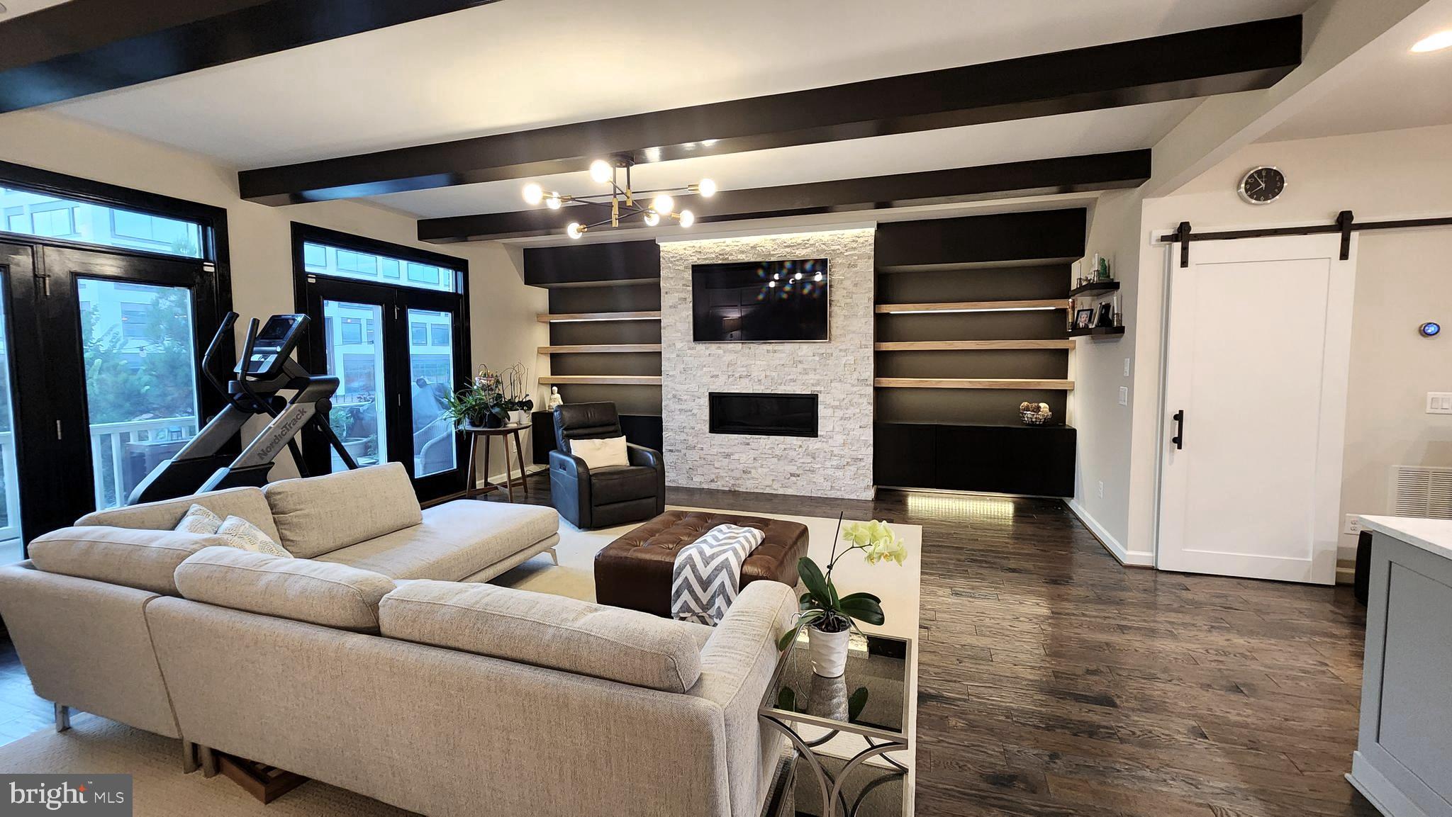 Welcome to this stunning 3200 sq ft townhouse located just minutes from Tysons Corner, West Falls Church Metro, shopping, dining, and major commuter routes! You're greeted with modern and open concept living. The gourmet kitchen is the centerpiece — a striking blend of form and function — featuring professional-grade stainless steel appliances, a five-burner range, an oversized island with bar seating, and expansive quartz countertops that invite culinary creativity and effortless entertaining. The main living spaces are bright and airy, flowing effortlessly from the formal dining area to the expansive family room adorned with custom built-ins and a cozy fireplace. A thoughtfully designed floor plan allows for both grand-scale entertaining and intimate gatherings, while large windows frame views of the city. Upstairs, the serene primary suite is a retreat of its own, offering an en-suite bath with dual vanities, and a walk-in shower. Additional bedrooms are generously sized with ample closet space ensuring comfort for family and guests. The fully finished lower level expands the lifestyle possibilities, with space for a home office, gym, or recreation room tailored to your needs. Outside, offering a upper deck / a lower private stone patio yard provides the perfect setting for alfresco dining, weekend barbecues, or simply enjoying a quiet evening under the stars. This 3200 sp ft home offers both space and seclusion just minutes from the vibrant Tysons Corner, with its plethora of shopping, dining and entertainment options,. Also located across the street from West Falls with many dining options, walking distance to West Falls Church metro, and major commuter routes: I-495, I-66, and top rated schools.