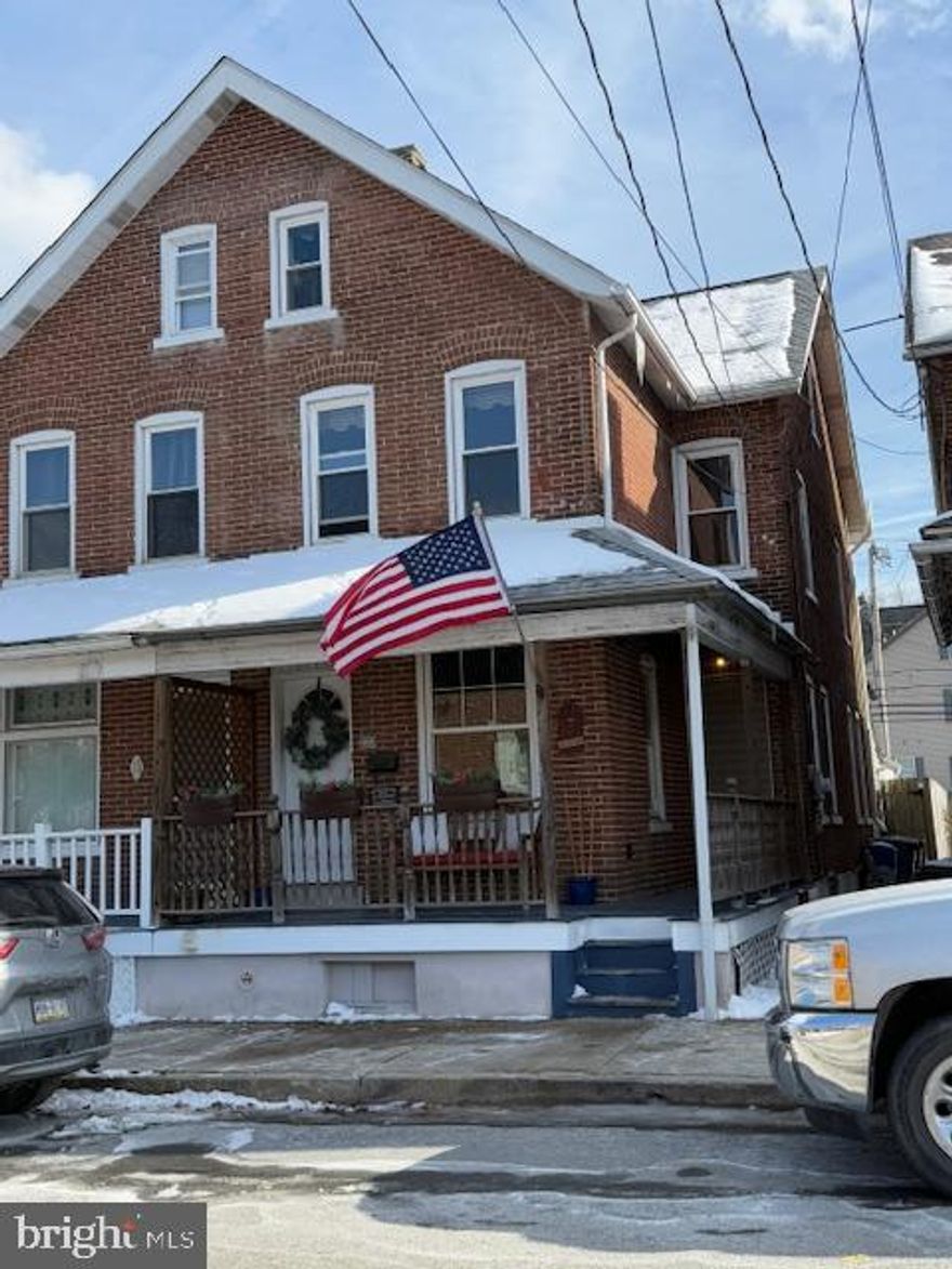 This 4-bedroom, 1.5 bath all-brick twin home with covered wrap-around porch is ready to welcome its new owners. Located within the quaint Borough of Emmaus/highly rated  East Penn School District, this home exudes charm and character.  Spacious living room featuring hardwood floors, pellet stove and ceiling fan give this home a cozy and welcoming feeling. A new stove was added to the updated kitchen in 2024.  Just off the kitchen is a half bath and mudroom leading out to the back yard.  The fenced in back yard has a covered patio, and beautiful landscaping around a small fish pond/waterfall feature.
There are three nice-sized bedrooms on the second floor featuring hardwood floors, which add additional appeal to this home. A finished attic with walk-in closet serves as a fourth bedroom or office/additional living space.  Detached garage is currently used as a music studio complete with electric and heat.  New roof in 2021, new furnace in 2020, and new half bath in 2019 all add tremendous value to this home. Conveniently located within walking distance to shopping and restaurants.  Close to I-78.