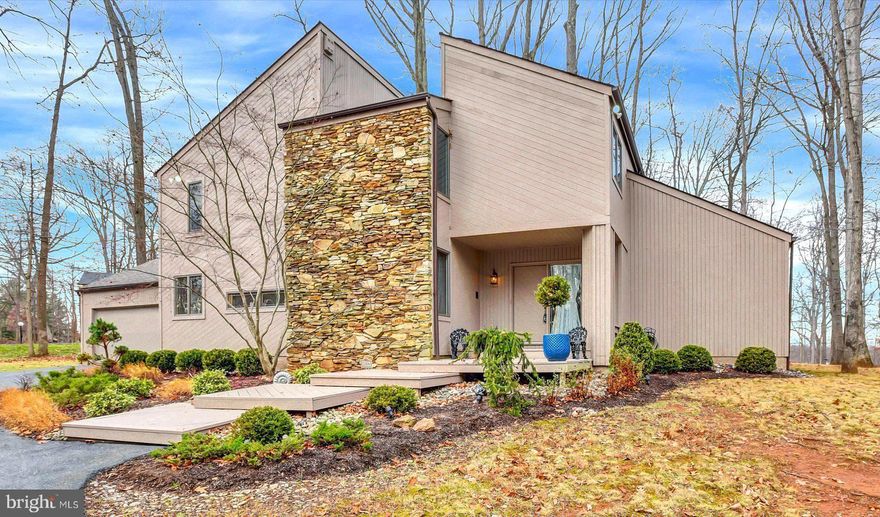 Significant Price Reduction! Discover the perfect blend of comfort and elegance in this stunning 4 bedroom, 3 bath contemporary stone accented home, nestled in the desirable Valley Heights subdivision. With 2,752 sq. ft. of meticulously maintained living space, this residence boasts a spacious open floor plan that invites natural light to dance across the hardwood and ceramic tile floors. Step inside to find a gourmet kitchen equipped with top of the line stainless steel appliances, beautiful oak cabinets, granite countertops, and an  island for leisurely meals. Ample table space is ideal for culinary enthusiasts and entertaining guests is easy with a pass through bar area to the family room which is conveniently located off the kitchen; featuring a stacked stone fireplace, creating a warm atmosphere for gatherings plus sliders to a huge deck overlooking 1+ acres of unspoiled nature! The 1st floor bedroom and bath offer a welcoming space for guests from far and near!  Retreat to the luxurious primary suite, boasting a double spa tub and fireplace to relax your night away. Complete with 2 walk-in closets, this bathroom features double sinks, and a walk-in shower plus a separate commode room. The exterior is equally impressive, set on a generous 1.13-acre lot with panoramic views of lush gardens and scenic vistas. Enjoy outdoor living on the expansive deck, perfect for summer barbecues or tranquil evenings under the stars. The extensive hardscape and exterior lighting enhance the beauty of the property while providing security with an electric alarm system. All systems in this lovely home have been upgraded including the HVAC which is 2 years new! Located in a serene suburban setting, this home offers the ideal escape while remaining conveniently close to local amenities. With an attached 2 car garage and circular driveway, parking is a breeze. This exceptional property is not just a house; it’s a place to create lasting memories. Don’t miss your chance to make it yours!