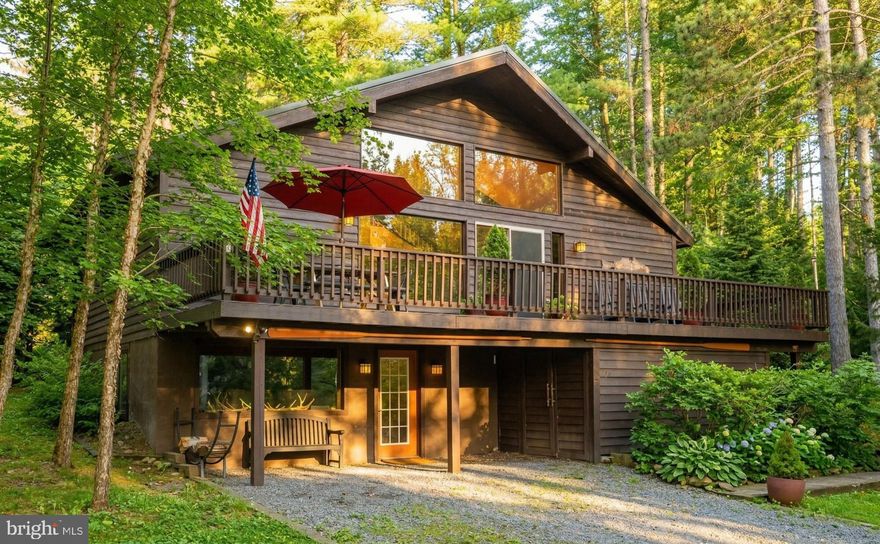 Tucked within the coveted Sky Valley community, this 3-bedroom, 3-bath chalet with a loft captures the timeless character of Deep Creek living. Rich wood finishes, vaulted ceilings, and a striking double-sided stone wood-burning fireplace create a warm and inviting main living space. The home offers multiple levels of living, including a fully finished lower level as well as a loft for flexible sleeping areas for guests. Outdoor living is just as appealing with a spacious deck and hot tub, surrounded by a peaceful wooded setting. Enjoy access to Sky Valley’s private lake amenities, including a swimming area, boat ramp, and picnic sites, with dock slips available through the HOA via waitlist. A true mountain retreat just minutes from everything Deep Creek Lake has to offer.