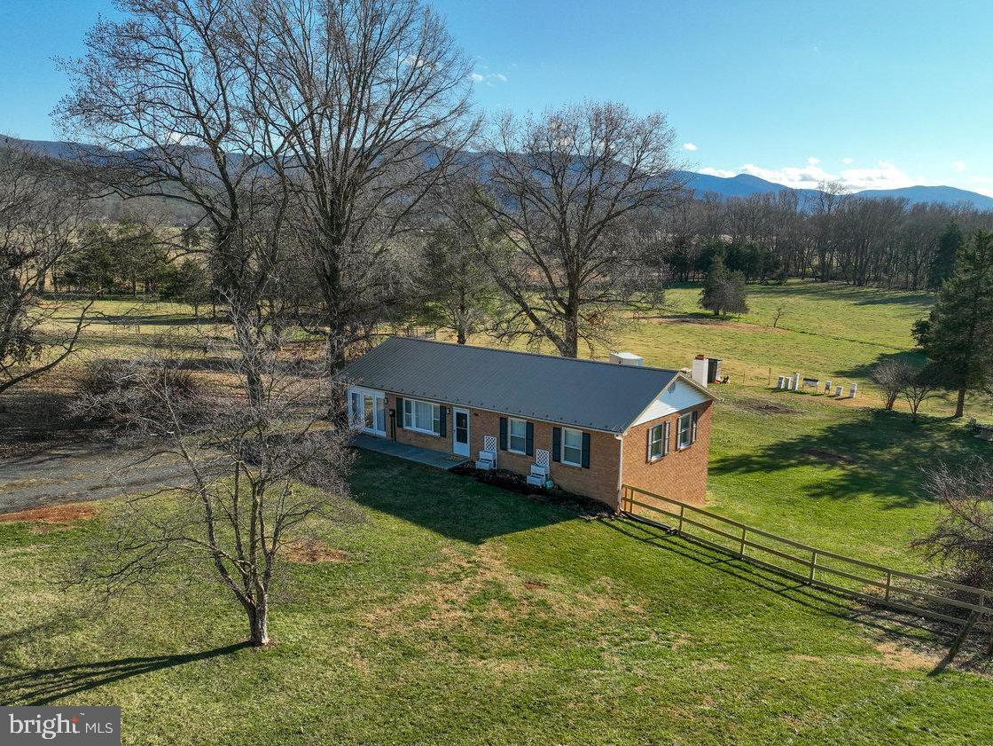 Welcome to this charming 4-bedroom brick ranch style home perfectly situated outside the scenic Town of Luray, Virginia on 2.5 private acres! This extraordinary / recently updated home located on a cul-de-sac offers four expansive bedrooms, two full bathrooms, and a spacious finished basement, providing generous space for comfortable year-round living. No HOA or road maintenance fees! Recent updates include brand-new central heating and air conditioning, ensuring modern comfort throughout the year, an idyllic woodstove for cozy evenings by the fire, as well as new flooring throughout, and a brand-new fence to keep your furry friends safe while they enjoy the great outdoors! Step out onto the rear deck and private patio to take in breathtaking views of the Shenandoah National Park and the neighboring farm — a truly serene backdrop for your morning coffee or evening relaxation while you gaze at the stars. Included with its peaceful rural setting, this home is conveniently located just minutes from downtown Luray, blending tranquility and seclusion with near in-town convenience. Explore the wonders of the Shenandoah National Park, Shenandoah River State Park, and the enchanting Luray Caverns, all just minutes away. Seek thrills at the year-round adventure hub of Massanutten Resort and lose yourself in the expansive beauty of the millions of acres of the George Washington and Jefferson National Forests. For those with refined tastes, nearby wineries, vineyards, and breweries await your exploration. If you are looking for your next investment in the cabin capital of Virginia, this home may be utilized as a short-term vacation rental under the current local zoning code by right (with no special use permit required)! Whether you are looking for a peaceful retreat, a fully updated home, or an income-generating investment property, this property truly has unlimited potential. Schedule your showing today to experience the charm of this idyllic retreat before it is too late!