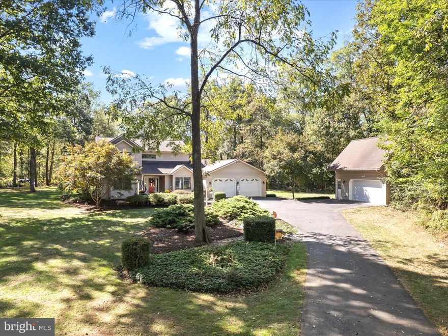 Peaceful 5.09 Wooded Acres in Apple Tree Farms - Welcome to 701 Cider Drive, a beautifully maintained 3-bedroom, 2.5-bath home offering over 2,200 sq. ft. of inviting living space. Nestled on 5.09 wooded acres, this property offers the perfect blend of privacy, comfort, and convenience. Step inside to an open floor plan featuring a spacious kitchen, dining area, and a vaulted-ceiling family room with a cozy woodstove—perfect for gatherings or quiet evenings at home. The main level includes two bedrooms, 1.5 baths, and a laundry area for easy one-level living. Upstairs, a large loft area leads to the primary suite, complete with an en suite bath, private deck, and a laundry chute to the main level for added convenience. Enjoy the outdoors from multiple spaces: a rear deck and patio ideal for entertaining or relaxing in nature, and a welcoming front patio area that adds charm and curb appeal. Set within a private, park-like wooded setting, the property also includes a 2-car attached garage and a detached 2-story garage—perfect for a workshop, hobbies, or extra storage. Located in the desirable Apple Tree Farms subdivision, this peaceful retreat is just minutes from major commuter routes, offering the perfect balance of seclusion and accessibility. All sizes are approximate. Enjoy the video tour!!  Offer deadline is Sunday 10/12 at 3:00p