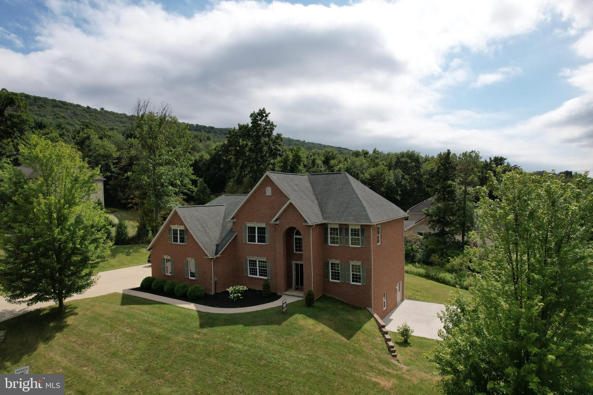 OPEN HOUSE - Sunday, August 31st, 1:00 - 3:00 PM. Welcome Home to Thistlewood Elegance! This stately, custom-built, one-owner brick home sits on just over an acre in one of State College’s most sought-after neighborhoods. Natural light pours through a beautiful arched window into the grand two-story foyer, where custom steel stair railings make a striking first impression—perfect for prom photos, holiday portraits, or warmly welcoming guests. Hardwood floors flow throughout the main level, where a formal living room with oversized windows is perfect for morning coffee or afternoon tea, and a formal dining room sets the stage for memorable gatherings. The well-appointed kitchen will delight any home chef with granite countertops, a 5-burner electric range with heavy-duty hood, rich wood cabinetry, a curved two-tier island, stainless steel appliances, a large refrigerator with double drawer, pantry, and double sink with a charming view of the backyard. Just off the kitchen, the sunlit breakfast area—complete with granite bar, additional cabinetry, bump-out window, and sliding door with transom—opens to a large composite deck, ideal for outdoor entertaining. The spectacular two-story great room is filled with natural light from soaring arched windows and features skylights, a gas fireplace, and a Juliet balcony—creating the perfect setting for both cozy evenings and joyful celebrations. For guests or flexible living, the main level also includes a spacious bedroom with large windows and closet (or second office) and an upgraded full bath with granite vanity, tub/shower, and ample storage. Upstairs, plush carpeting and high ceilings frame a thoughtful layout. The expansive primary suite includes a tray-ceiling bedroom, walk-in closet, private study/nursery, and spa-inspired bath with jetted tub, custom-tiled walk-in shower, double vanity, and abundant natural light. A second ensuite bedroom with private bath is joined by two additional bedrooms, a dual-vanity full bath, and a convenient laundry room. The unfinished walk-out lower level offers ample storage and excellent potential for future customization, featuring a rough-in bath, daylight window, and a full double door leading to a concrete patio. An oversized concrete driveway and spacious three-car garage provide ample parking, storage, and workshop space. Meticulously maintained, this home also features geothermal heating and cooling, 9+ foot ceilings, central vacuum, ceiling fans, and charming front window candle outlets that add a touch of seasonal warmth. Located just minutes from Penn State and nestled at the foot of Tussey Mountain, this exceptional residence offers the perfect blend of comfort, convenience, and timeless elegance.