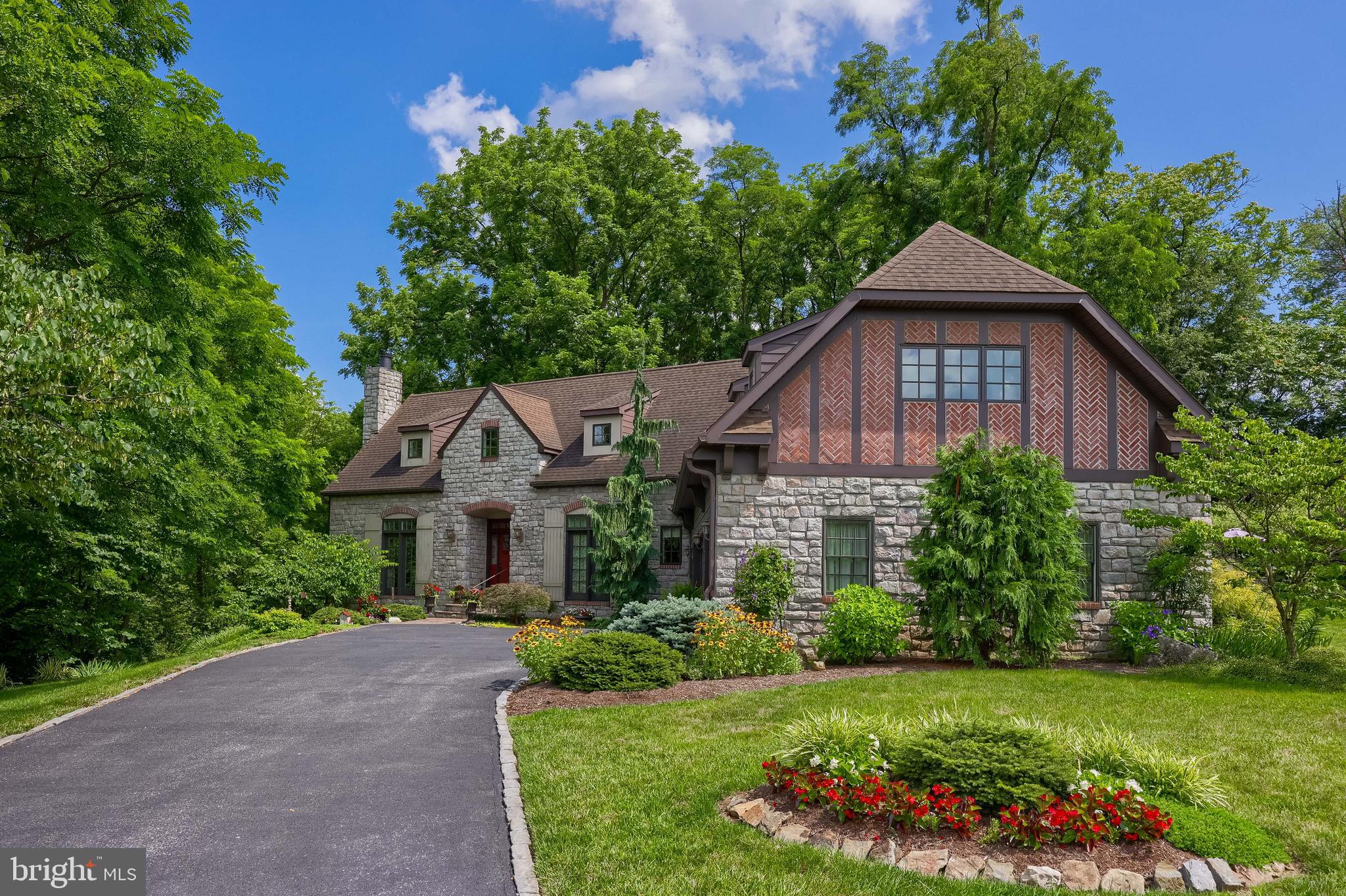 Welcome to this expertly crafted home in the Carrington community, where comfort meets nature in perfect harmony. The property backs to a peaceful walking trail and features a beautifully landscaped yard with over 75 flower varieties, many of them perennials, and 18 mature redbud trees, offering seasonal color, privacy, and natural beauty. A gently flowing stream winds through the backyard, enhancing the tranquil setting, along with views of the adjacent lot pond. Nestled in a private, semi-wooded setting, a flagstone patio offers an ideal retreat for relaxing or entertaining. Offering four bedrooms, three and a half baths, and an oversized three-car garage, the home provides generous living space and timeless appeal. As you enter, cork flooring spans much of the main level, adding warmth and eco-conscious design. To the left of the foyer, the formal dining room features a tray ceiling, wainscoting, crown molding, and recessed lighting, creating an elegant atmosphere. The eat-in kitchen is both functional and stylish, with marble countertops, a Jenn-Air cooktop stove and oven, dishwasher, refrigerator, pantry, and recessed lighting. The space flows into a large great room with vaulted ceilings, plush carpeting, a ceiling fan, custom built-ins, and a gas fireplace. The main-level primary suite, set apart for privacy, includes carpet flooring, a ceiling fan, and dual walk-in closets. The ensuite bath offers a double vanity, sconce lighting, and a walk-in shower. A private hot tub jacuzzi is located just off the primary suite. A separate office on the main level provides a quiet and flexible space suitable for work or hobbies. The laundry room includes a high-end Fisher & Paykel washer and dryer. Upstairs, two bedrooms are connected by a Jack-and-Jill bathroom. An unfinished attic with vaulted ceilings offers additional potential for storage or future living space. The walk-out lower level, with luxury vinyl plank flooring features a large recreation room with a wood-burning fireplace and wet bar, complete with center island and pendant lighting. A fourth bedroom with ensuite bath and walk-in closet adds privacy and comfort. Additional storage includes a utility room. Outdoor living features include a screened-in porch, hot tub, a stone patio, and a waterproof upper deck that provides both entertaining space and covered storage below. The backyard’s thoughtful landscaping adds privacy and year-round interest. A charming spring house offers added utility for storing garden tools or outdoor gear. Conveniently located near Manheim Township High School and Landis Run Intermediate School, the home is close to Lancaster Airport, grocery stores, a movie theater, UPMC medical facilities, and both Downtown Lititz and Downtown Lancaster. Schedule a private showing to explore everything this one of a kind property has to offer.