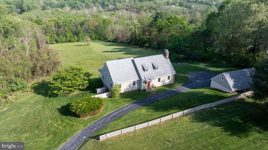 Purchased in 1978, this property is a 21+ acre subdivision of a 70 acre farm.  The owners have truly loved the quiet, country life of Chester Springs, with its rolling hills, farms, streams, wooded trails and equestrian possibilities. . . . . . . . The home was custom designed and built in 1979 by Mr. James G. Cherry of Glenmoore, who specialized in building and historically restoring Chester County homes.  His style incorporated colonial building techniques and some vintage materials into his work.  In this home, the beams in the main living area were taken from a log house in Lancaster County. . . . . . . . The style is Cape Cod with colonial farmhouse features, partially constructed of brick with a slate roof.  This home was designed, built, and has been meticulously maintained with an attention to detail. . . . . . . . The main living area offers a colonial open-hearth fireplace and random width wood hardwood planks with beamed ceilings. The dining space has unobstructed, expansive views of the valley below looking down to Pigeon Run Creek and off to the hills in the distance. . . . . . . . The primary bedroom is on the first floor with a private bath and doorway access to the rear covered porch.  White-tail deer, fox, hawks and other abundant wildlife may be viewed from the comfort of your rockers. . . . .  . . The first floor also includes recently refreshed, hardwood, kitchen cabinetry with ceramic tile floor, home office / bedroom, foyer, mudroom and half bath.  Portions of the hallway walls are wood panels designed to add texture and architectural definition. . . . . Farmhouse stairs take you to the second-floor landing, two bedrooms and full hall bath.  In addition, there is as a 20 x 15 ft exercise /  multi-purpose room and  unheated, 20 x 20 ft storage room, which has the potential to be a fourth bedroom. . . . . . . . . The basement is of block construction and offers laundry facilities, significant storage with ground level outside access to the rear yard.  There is also a large crawl space for easy access to utilities and storage. . . . . All carpeted areas are brand new. . . . . . . . The property includes an open-bay two car garage with driveway level storage area and a second-floor workshop.  The front yard has a fully fenced professional tennis court and backboard. . . . . . .  . The home is equipped with a whole house automatic backup generator to provide seamless backup power. Two wells service the property; one for the home with the second for the garage / workshop area and irrigation. . . . . The property has been granted a property tax abatement from Chester County under the Act 319 / 515 "Clean & Green" program.  The tax reduction is for keeping the land as a farm, forest or open space.   The annual tax bill for the property in 2026 is $4,565. . . . . . . . Subdivision possibility of the front acreage is unknown.  If the land changes use, rollback taxes of up to 7 years plus interest would be required. . . . . . . . . Schools are provided by the Downingtown Area School District, including the Lionville Elementary and Middle Schools and Downingtown High School East Campus.  Students have the opportunity to apply for the Downingtown S.T.E.M. Academy, a public high school and an International Baccalaureate World School. . . . . . . . The Pennsylvania Turnpike, routes 113, 100 and 30 are easily accessible. . . . . . . . Please come and see this opportunity to own a piece of Chester County living with an amazing view.