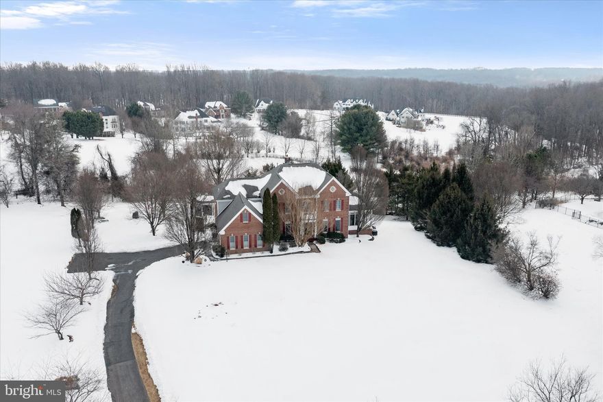 Nestled on a premium lot in the highly desirable Hunterbrooke community, this impressive custom-built home has been meticulously maintained by its original owner and thoughtfully upgraded throughout. With brick on three sides and no expense spared, this residence offers exceptional craftsmanship, timeless elegance, and an outstanding outdoor retreat. The expansive backyard provides rare privacy, backing to preservation land and featuring a composite deck, gazebo, and fire pit, creating the perfect setting for entertaining or peaceful relaxation. Step inside to a stunning two-story foyer highlighted by elegant lighting and architectural columns. Formal living and dining rooms flank the entry, showcasing crown molding, chair railing, wainscoting, and sun-drenched windows. Gleaming hardwood floors span the main and upper levels, complemented by custom window treatments, Plantation shutters, recessed lighting, custom ceiling fans, dual staircases, and an interior and exterior intercom system. All bathrooms have been beautifully renovated, enhancing both style and comfort. The beautiful kitchen is designed for both functionality and entertaining, featuring granite countertops, a sleek tile backsplash, stainless steel appliances, gas cooking, a center island, walk-in pantry, prep sink, display cabinetry, wet bar, and a spacious casual dining area. The adjoining morning room offers direct access to the deck, perfect for enjoying your morning coffee with tranquil views. The expansive family room, complete with one of three gas-burning fireplaces, provides an inviting space to unwind. A private home office, light-filled conservatory, laundry room, and powder room complete the main level. Upstairs, the luxurious primary suite is a true sanctuary, offering hardwood floors, tray ceiling, crown molding, a three-sided fireplace, sitting room, dressing room, and two impressive walk-in closets. The renovated (2021) spa-inspired primary bath features dual vanities, a freestanding soaking tub, a water closet, and an oversized shower with multiple shower heads, seating, and a Bluetooth music feature. Three additional spacious bedrooms, including one with an en suite bath and another dual-entry bath, complete the upper level. The finished walk-out lower level offers exceptional versatility with a large recreation room featuring a gas fireplace, surround sound, and wet bar. Additional spaces include a fifth bedroom or exercise room, full bath, second office, media room, hobby room, workshop, and ample storage. Recent updates include a roof, all bathroom renovations, two AC units, cooktop, refrigerator, washer, and dryer (2015–2018). Oversized two car garage with additional spaces to accommodate 10-12 cars.  Ideally located just minutes from major commuter routes, this extraordinary home offers the perfect blend of luxury, comfort, and convenience. This is the one you have been waiting for!