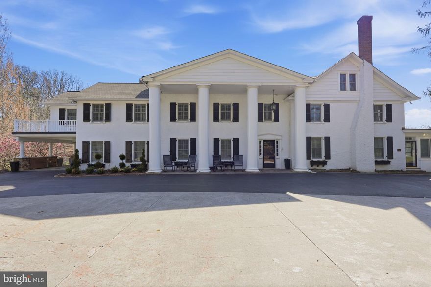 Glenloch Manor is the rare property that delivers both architectural presence and true compound living. Positioned behind wrought-iron gates and approached by a long, multi-car drive, this 11-acre estate unfolds around a picturesque heart-shaped pond with bridges, fountain, gardens, play areas, and curated outdoor living spaces. Privacy is absolute. The lifestyle is expansive. The Main Residence - A stately Greek Revival façade with grand columns and a classic shingle roof sets the tone. Inside, historic character meets modern luxury across thoughtfully renovated spaces designed for both large-scale entertaining and comfortable daily living. The main level welcomes you with a stone-tiled foyer and flows into elegant formal rooms, multiple wood-burning fireplaces, a refined dining room, and a richly appointed family room with custom bar. The gourmet kitchen is a true centerpiece, featuring marble countertops, white cabinetry, Wolf six-burner range, wine refrigeration, expansive breakfast area, and seamless connection to a prep/bar kitchen and sunroom overlooking the grounds. A game room, office/sitting room, and covered patio/carport extend the entertaining footprint. The lower level offers exceptional versatility with a secondary kitchen, full bath, finished recreation area with wood stove, gym, sauna, wine cellar, additional laundry, and extensive storage/mechanical space. A whole-house generator, hot water heat, well system, and upgraded infrastructure provide peace of mind. Upstairs, the primary suite is its own private retreat, complete with gas fireplace, expansive sitting room, private office with balcony access, massive custom dressing room with integrated laundry, and a spa-inspired bath. Additional bedrooms include princess suites and cedar-lined storage, each designed with comfort and privacy in mind. A top-level loft bedroom and sitting area add yet another flexible living space. The Carriage House - The oversized two-car carriage house with gas HVAC and hot water offers fully independent living. Hardwood floors, open living spaces with wood-burning fireplace and balcony, white kitchen with quartz counters and stainless appliances, multiple bedrooms including a primary suite, full baths, dedicated laundry, and a third-floor loft with mini-split climate control create an ideal guest residence, multigenerational suite, or private office retreat. The Luxury Barn House - The barn is nothing short of spectacular. With a metal roof, open-concept design, concrete floors, reclaimed finishes, full kitchen and bar with granite counters and antique oak cabinetry, large pantry, wood-burning stone fireplace, covered patio, and climate control, it functions as a next-level entertainment venue. Upstairs, a dramatic open gathering space, powder room, and dedicated cigar lounge elevate the experience even further. The Retro-Inspired Pool House (pics coming soon) - Positioned for effortless summer living, the pool house features slate flooring, sliders to outdoor entertaining areas, full kitchen with electric cooking, full bath, upper-level space, and mini-split comfort. A hot tub, aerated pond, and lush grounds create a resort-style atmosphere rarely found in private estates. The Grounds & Infrastructure - The property is as functional as it is beautiful, offering sprinkler system, centrifugal pump, solar array for efficiency, multiple car parking areas, covered patios, and expansive driveways. The pond, gardens, bridges, and mature landscaping create a setting that feels both curated and natural. Located just minutes from New Hope, Doylestown, and Newtown, Glenloch Manor delivers complete seclusion without sacrificing convenience. This is a legacy property designed for those who want space to gather, space to retreat, and the flexibility to live expansively. A true family compound where every structure serves a purpose and every detail supports a lifestyle few properties can offer.