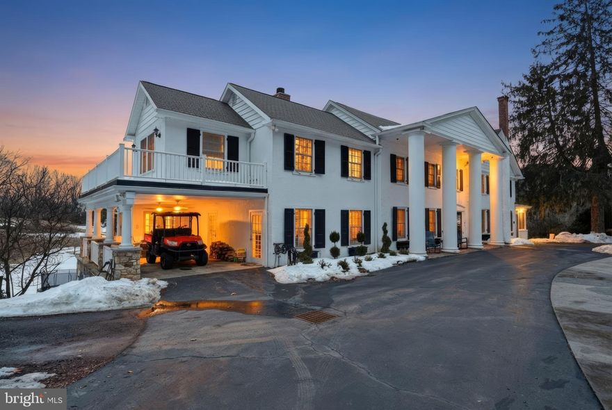 Glenloch Manor is the rare property that delivers both architectural presence and true compound living. Positioned behind wrought-iron gates and approached by a long, multi-car drive, this 11-acre estate unfolds around a picturesque heart-shaped pond with bridges, fountain, gardens, play areas, and curated outdoor living spaces. Privacy is absolute. The lifestyle is expansive. The Main Residence - A stately Greek Revival façade with grand columns and a classic shingle roof sets the tone. Inside, historic character meets modern luxury across thoughtfully renovated spaces designed for both large-scale entertaining and comfortable daily living. The main level welcomes you with a stone-tiled foyer and flows into elegant formal rooms, multiple wood-burning fireplaces, a refined dining room, and a richly appointed family room with custom bar. The gourmet kitchen is a true centerpiece, featuring marble countertops, white cabinetry, Wolf six-burner range, wine refrigeration, expansive breakfast area, and seamless connection to a prep/bar kitchen and sunroom overlooking the grounds. A game room, office/sitting room, and covered patio/carport extend the entertaining footprint. The lower level offers exceptional versatility with a secondary kitchen, full bath, finished recreation area with wood stove, gym, sauna, wine cellar, additional laundry, and extensive storage/mechanical space. A whole-house generator, hot water heat, well system, and upgraded infrastructure provide peace of mind. Upstairs, the primary suite is its own private retreat, complete with gas fireplace, expansive sitting room, private office with balcony access, massive custom dressing room with integrated laundry, and a spa-inspired bath. Additional bedrooms include princess suites and cedar-lined storage, each designed with comfort and privacy in mind. A top-level loft bedroom and sitting area add yet another flexible living space. The Carriage House - The oversized two-car carriage house with gas HVAC and hot water offers fully independent living. Hardwood floors, open living spaces with wood-burning fireplace and balcony, white kitchen with quartz counters and stainless appliances, multiple bedrooms including a primary suite, full baths, dedicated laundry, and a third-floor loft with mini-split climate control create an ideal guest residence, multigenerational suite, or private office retreat. The Luxury Barn House - The barn is nothing short of spectacular. With a metal roof, open-concept design, concrete floors, reclaimed finishes, full kitchen and bar with granite counters and antique oak cabinetry, large pantry, wood-burning stone fireplace, covered patio, and climate control, it functions as a next-level entertainment venue. Upstairs, a dramatic open gathering space, powder room, and dedicated cigar lounge elevate the experience even further. The Retro-Inspired Pool House (pics coming soon) - Positioned for effortless summer living, the pool house features slate flooring, sliders to outdoor entertaining areas, full kitchen with electric cooking, full bath, upper-level space, and mini-split comfort. A hot tub, aerated pond, and lush grounds create a resort-style atmosphere rarely found in private estates. The Grounds & Infrastructure - The property is as functional as it is beautiful, offering sprinkler system, centrifugal pump, solar array for efficiency, multiple car parking areas, covered patios, and expansive driveways. The pond, gardens, bridges, and mature landscaping create a setting that feels both curated and natural. Located just minutes from New Hope, Doylestown, and Newtown, Glenloch Manor delivers complete seclusion without sacrificing convenience. This is a legacy property designed for those who want space to gather, space to retreat, and the flexibility to live expansively. A true family compound where every structure serves a purpose and every detail supports a lifestyle few properties can offer.