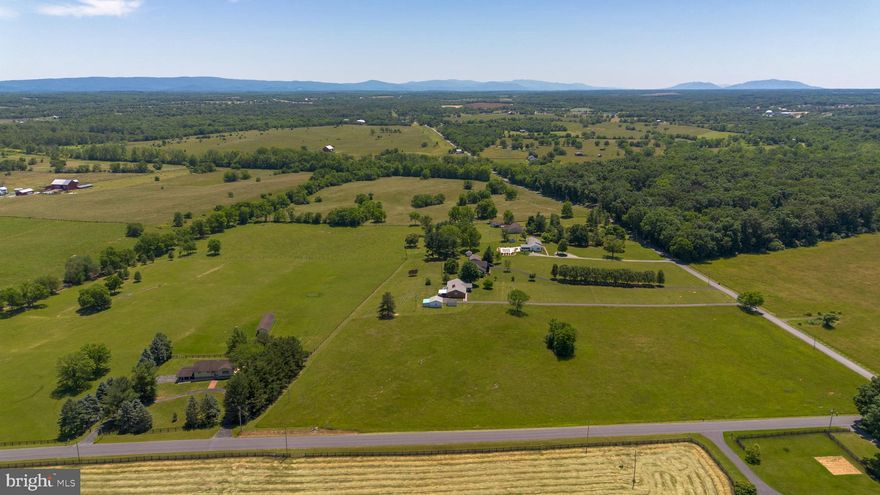 Gorgeous 360° views of the Blue Ridge mountains! Low taxes with land use capabilities (side field is currently farmed for hay so bring your animals!  This lovely property is surrounded by horse farms, perfect for  equestrian, animal or farm enthusiasts. Enjoy the privacy of sipping your coffee in the glass sunroom overlooking fields in the beautiful Shenandoah valley. This all-brick home situated on a level 8.48 acre lot off paved road features 3 bedrooms and 2 baths on the main level plus an unfinished basement that has 2 private entrances. French provincial style kitchen includes all custom cabinetry and upgraded Jenn-Air appliances. Great location off Rt 7 only a few minutes to downtown shopping in Berryville or Winchester and only a few miles to the Shenandoah River nature trails and water activities. The attached carport can be perfect for your vehicle or an additional breezy outdoor living space.  Oversized 2-car detached garage has an additional 12x24 storage area attached to it plus an additional shed that conveys.  Meticulously maintained and move in ready!