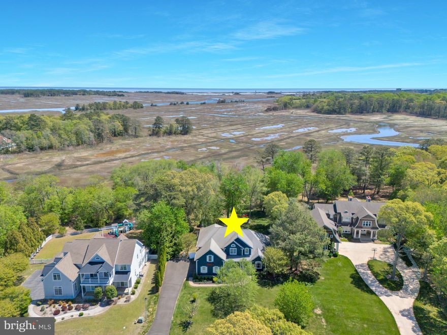 Welcome to the Artist's Retreat - the perfect combination of traditional coastal charm and contemporary living. Located in the highly desirable and well-established community of Wolfe Pointe, this home is situated on over an acre of property, offering stunning views of the marshland and state park, showcasing the WW2 observation towers at Gordons Pond visible in the distance. Spread out over 5,000 square feet, this luxurious home features 4 bedrooms, 4 1/2 baths, an expansive open floor plan, hardwood floors, and a large bonus room over the garage. Additionally, there is a butler's pantry and a full finished basement. Upon entering, you will notice the 2-story ceilings throughout the foyer and great room. To the left is a stunning formal dining room, and to the right is a large private office. As you continue into the great room, you'll be drawn to the vast and expansive views of the marsh and the towers in the distance. A modern and contemporary corner fireplace offers a cozy spot to relax on those cool evenings at the beach. Just beyond the great room is the breakfast area, which leads you to the kitchen. Sleek Kitchen Aid appliances include a built-in wall oven with separate microwave, counter-depth refrigerator, and a 6-burner gas cooktop. The island is expansive and features a prep sink for the chef of the house. A separate butler's pantry provides additional cooking and prep space, featuring a second wall oven and refrigerator. Just beyond is the laundry room and entrance to the garage. The primary suite is located on the main level and offers views of the marsh and abundant wildlife. An updated bathroom features a double vanity, a large shower, a soaking tub, custom tilework and cabinetry, and a spacious walk-in closet with custom shelving.
Upstairs, there are three guest bedrooms: the Commodore room with an en-suite bath, followed by the Sea Grass and Flamingo rooms, which share a Jack-and-Jill bathroom. There is a finished bonus room over the garage, which could serve as a 5th bedroom or a playroom. Each of these spaces has been meticulously designed with custom wallpaper by Thibaut, creating a fun and playful theme that carries throughout each bedroom.
The basement is fully finished, featuring a rear wall of windows and an ingress/egress door that allows for ample natural light to fill the space. In the center of the basement is a wet bar for parties/entertaining. Additional storage and a workshop can be found throughout the basement in addition to the finished workout studio.
Please note that the basement is currently used as an active artist's studio.
A custom-built shed can be used for additional storage of yard or beach equipment.
The setting of this property offers abundant privacy while still taking full advantage of the spectacular views. Schedule a tour before it's gone!