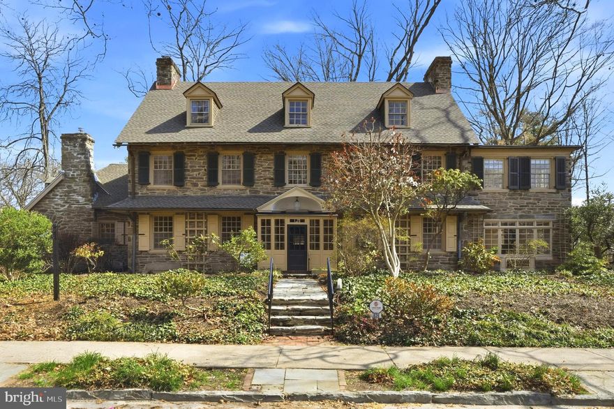 Step into timeless elegance with this exquisite Wissahickon stone center-hall colonial, an architectural masterpiece crafted in 1910 by the renowned Philadelphia firm of Duhring, Okie & Ziegler. Nestled on 1.2 acres of picturesque grounds, this 5,570 sq. ft. residence is a harmonious blend of historic charm and modern comfort, boasting 5 bedrooms, 4.5 bathrooms, and no fewer than 5 fireplaces—4 wood-burning and 1 gas-fired.

As you enter through the Dutch front door, you're greeted by a grand central hall with gleaming refinished oak floors, intricate wainscoting, high ceilings, and a formal staircase that exudes sophistication. Fluted casings frame the entryways, inviting you into the heart of the home. To the right, the expansive living room (27' x 17') enchants with picture-frame molding, a marble-framed fireplace, and French doors that lead to an all-season sunroom. Here, you’ll find built-in cabinetry, gravel beds for greenery, and its own cozy fireplace. The sunroom extends, through sliding glass doors, to a flagstone terrace, the perfect backdrop for outdoor entertaining or serene moments overlooking the wooded lot.

To the left of the hall lies a formal dining room (20' x 17') with a striking granite-framed fireplace, a brass chandelier, and a wood-carved mantel that whispers of craftsmanship from a bygone era.  Adjacent is a butler’s pantry, a charming powder room with a barrel ceiling, and a thoughtfully designed eat-in kitchen (15' x 15'). The kitchen features granite countertops, a functional work island, stainless steel appliances, including a new gas range with a convection oven , and a window seat offering tranquil backyard views through a lovely triptych window.  A nearby mudroom with a Palladian window and abundant storage adds practicality to the home’s graceful design.

Ascend to the second floor, where French doors open to a light-filled study, or art studio (16' x 9'), with exposed beams and panoramic views of the lush rear yard. This level offers two spacious bedrooms, each with its own bath, and one with a wood-burning fireplace. The pièce de résistance is the luxurious primary suite, complete with its own library or home office (17' x 17') featuring built-in bookshelves and a gas fireplace. The suite also includes a grand bedroom (23' x 14'), a dressing room, and a spa-like tiled bathroom with a large stall shower. The third floor offers two additional bedrooms (20' x 15') and a shared hall bath, perfect for guests or family.

The property’s outdoor amenities are equally impressive. Beyond the stone parking area and charming wooden gate lies a private retreat: an in-ground swimming pool and a heated pool house. Formerly a garage, the pool house features a flagstone floor, a hot tub, a cedar-lined sauna, and a full bathroom. Upstairs, a one-bedroom apartment with a living room, kitchenette, and bath provides a private haven for guests or extended family. A boardwalk meanders through the adjacent wooded lot, leading to a tranquil seating area ideal for birdwatching or meditation.

Designed by a firm celebrated for their "comfortable, homelike qualities," this historic home offers a rare opportunity to own a piece of architectural heritage while enjoying the luxuries of modern living. This is more than a house—it's a lifestyle of elegance, warmth, and timeless beauty, located in West Mt Airy, minutes to Fairmount Park, Rt 76,  and Center City.