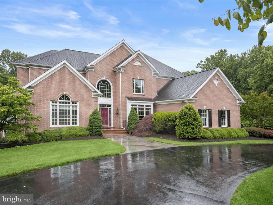 Tucked away on a premium 6 acre lot in complete seclusion and surrounded by lush woods, this stunning all brick colonial estate offers over 8,000 sq. ft. of luxurious living space with an exceptional private retreat with refined indoor living and resort-style outdoor amenities. A long, tree-lined driveway leads to a beautifully maintained home set on subdividable acreage, featuring a heated saltwater PebbleTec pool, expansive patio, multiple decks, and an open yard ideal for entertaining or quiet enjoyment.  Inside, a dramatic two-story foyer welcomes you with a Palladian window, elegant accent moldings, and rich Brazilian cherry hardwood floors that carry throughout the main and upper levels. The great room stuns with soaring ceilings and a rustic stone gas fireplace, flowing seamlessly into the gourmet kitchen. Perfectly designed for entertaining, the kitchen features an oversized island, granite countertops, stainless steel appliances including a Sub-Zero refrigerator, wood cabinetry with display shelving, and a bright breakfast room and sitting area with access to the rear deck.   The main-level primary suite is a private sanctuary with a tray ceiling, its own deck and hot tub, a custom walk-in closet, and a spa-like en suite bath complete with Turkish marble tile, an oversized dual-head shower, jetted tub beneath a skylight, a dual granite vanity with built-in cabinetry, and a wet bar. A powder room, laundry room, and mudroom with built-in hall tree and bench connect to the oversized garage, completing the main level.  Upstairs, the guest suite impresses with a deep tray ceiling and luxurious en suite bath featuring a Kohler bubble soaking tub, shower, and dual vanity. Three additional well-sized bedrooms, including one with a private bath, and a stylish hall bathroom provide flexible and spacious accommodations.  The walkout lower level is designed for entertaining, offering a large recreation and game room with a half bath and French doors to the pool and patio, a hobby, bedroom/ flex room, and abundant storage space.  Every detail of this home has been thoughtfully updated, including a 50-year roof, new insulation, roof sheathing, fascia and trim, tankless water heaters, modern HVAC systems, a recirculation pump, and a variable-speed pool pump. Additional upgrades include remote-controlled Hunter Douglas blinds, a Sonos sound system throughout the interior and exterior, and a Generac whole-house generator. The home offers over 1,000 gallons of stored water and an extensive circular driveway and two pads for guest parking.  Perfectly located with convenient access to major commuter routes, shopping, dining, and outdoor recreation, this home offers a rare blend of luxury, comfort, and privacy in a truly one-of-a-kind setting.