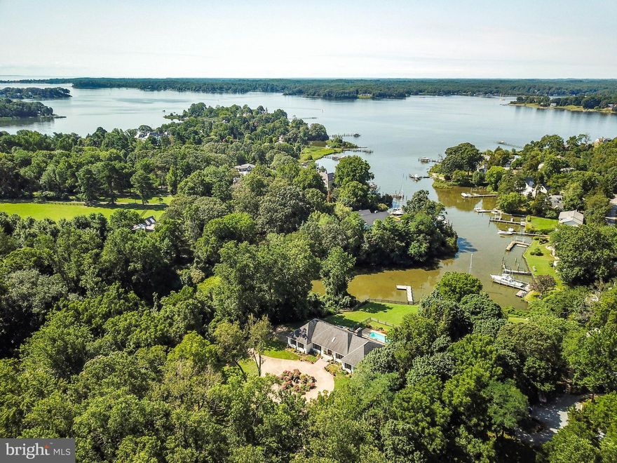 This unique two acre waterfront property in the highly sought after Wild Rose Shores community is a tranquil estate just minutes from downtown Annapolis.  Located at the head of Little Aberdeen Creek, the property offers over 100 ft. of private water frontage with easy access to the South River. The surrounding woodlands and the fully fenced grounds provide a retreat like setting with a perfect sloping lawn leading to the waterfront and pier. The fully renovated home will leave you breathless.  A fantastic layout of 3400 square feet single-level living, with careful renovations over the past two years that have resulted in a timeless, contemporary coastal style retreat.  Entering the gracious foyer, you are greeted with immediate views through the house to the waterfront beyond.  The large living room has a ship lap surround wood burning fireplace and an open floor plan with a beautifully renovated kitchen, all with expansive creek views and sliding doors to the south facing patio and salt water pool.  Wide plank light oak flooring extends from this beautiful open living room to the kitchen and throughout the rest of the home. The kitchen features custom white cabinetry, a commercial style Wolf gas range with stainless steel hood, an oversized stainless steel Sub Zero refrigerator and freezer, and beautiful quartz countertops.  These are just a few of the elements that result in a truly gourmet experience. The kitchen island cabinetry is a stylish contrasting navy blue, with plenty of bar seating for family and friends to gather while you create wonderful meals.  The space and flow here are so generous that you can choose between casual dining by the kitchen, or walk through the butlers pantry with a built in bar to a more formal dining room.  A large den off the front entry also provides the option for a home office or a separate media room, and built in cabinetry for plenty of storage.The main hallway leads you to a very large master bedroom with a charming decorative fireplace.  The master bathroom has stunning finishes.  Here you will find a large walk in glass enclosed shower, and a pedestal soaking tub with water views.  The dual sink vanity has plenty of storage, and no detail in the layout and organization of this space was overlooked.  The large master walk in closet also has a professionally installed organization system.  Sliding doors from the master bedroom lead directly to the back patio and a hot tub right outside your bedroom door.Two additional bedrooms are very generous in size, with large closets and tall windows providing lots of natural light.  These bedrooms overlook the mature gardens and water fountain along the front of the home.  The newly renovated hall bathroom features a tub/shower combination with beautiful tile surround.Off the kitchen you will be greeted by a unique herringbone tile floor leading to the full guest bathroom and the laundry room of your dreams.  The front loading washer/dryer are surrounded by custom cabinetry and granite countertops, making household work less of a chore.  There is no lack of natural light with a laundry sink window that also overlooks the pool and waterfront.   A two car attached garage is tucked out of site with convenient side entry to the laundry area and  kitchen.The home also features a large unfinished walk out basement with high ceilings, additional fireplace and over 3,000 square feet of potential with endless possibilities.To top it all off, this home comes with a huge owned solar panel system in conjunction with the extensive energy efficiency updates that dramatically reduce the energy use for the home.No detail has been overlooked and the result is a cohesive, elegant and comfortable home ready for your new waterfront lifestyle.