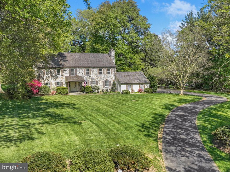 When you dream of a home that’s warm, inviting, spacious, and full of original character, surrounded by scenic beauty where lasting memories are made, it’s 7 Locust Lane that comes to mind. Hidden away at the end of a quiet cul-de-sac in sought-after Rose Valley, this meticulously maintained, almost 3300 sqft classic center hall colonial offers 4 bedrooms, 2 full and 2 half bathrooms, a 2-car garage, a sprawling backyard retreat, modernized HVAC, and placement in the award-winning Wallingford-Swarthmore School District. A long, tree-lined street leads to the home’s picture-perfect curb appeal, showcased by a handsome stone facade, manicured lawn, winding driveway, and a canopy of mature trees that create a peaceful, secluded setting. Inside, an inviting foyer welcomes you with a coat closet and rich woodwork that sets the tone for the interior. Beautiful hardwood floors extend into a large living room with a cozy fireplace and a dramatic multi-pane window framing the wooded backyard, perfect for entertaining and everyday living. Across the hall, the dining room trimmed in chair rail is ready for hosting, while a comfortable den with a second fireplace and built-in bookcases offers another place to relax. The main level is completed by a spacious kitchen with stainless steel appliances and a pantry, a convenient powder room, and a bright sunroom where you can take in the scenic surroundings year-round. Heading upstairs, a striking arched window at the landing captures picturesque backyard views. On one wing of the second level, the huge, sunlit primary suite boasts hardwood floors, double closets, and a private bathroom. Down the hall are three more bright, spacious bedrooms and a full hall bath, along with generous closet space. Adding to the home’s flexibility is a walk-up attic and a full basement with a powder room, providing excellent storage and potential for future finishing. In addition to everything inside, the expansive backyard is surrounded by mature trees for added privacy, featuring a patio for al fresco dining, garden space to perfect your green thumb, and plenty of open grass for outdoor play on long summer days. Recent upgrades to the home include a “55-year” cedar shake roof, a high-efficiency propane boiler with a 1,000-gallon underground tank, multi-zone central A/C, and a whole-house generator for added peace of mind. 7 Locust Lane’s sought-after Rose Valley location is both private and convenient, creating the best of both worlds. A path along the property leads directly to Brookhaven Rd across from Strath Haven High School, and the Rose Valley Swim and Tennis Club is at the opposite end of the block. Nearby, Downtown Media has top restaurants, local shops, and community events, plus walking trails, museums, theaters, markets, and shopping centers are all close. There’s also easy access to Rt-1, I-476, I-95, and Center City Philly via the Wallingford Train Station. Schedule your tour today!