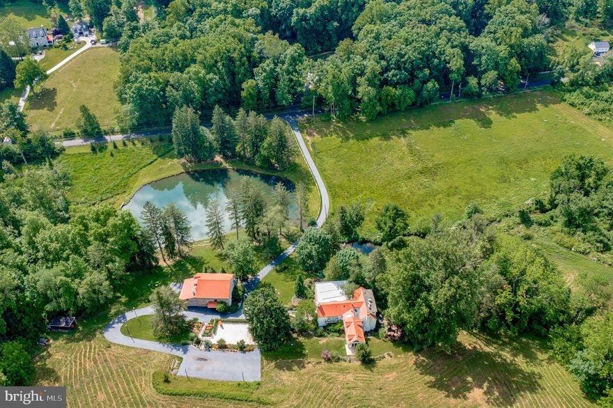 Welcome to Hunting Hill Farm, where timeless traditional design blends seamlessly w/modern sophistication on this stunning Gentleman's Farm, enveloped by 41+ plush acres in the beautiful, coveted  Birchrunville.  Escape into nature while still being w/in reach of  KoP , Turnpike & 
CC.  Long, private drive, passes the expansive meadows &  tranquil pond,  cross the bridge over the babbling stream, past the quaint red roofed Spring house, & there, in front of you, standing proudly, is the magnificent stone & glass1800’s Bank Barn: A blend of rustic charm & modern luxury. Step inside to discover a sprawling Entertainment Space w/ wood flrs, 2 story beamed clgs &stone walls. Gaze through the stone archway & catch a glimpse of the awe-inspiring views of the pond & grounds. Step through & be led to the Dining Rm & Bar. 3 glass walls & 2 balconies provide panoramic views & the sounds of the rush of the waterfall & bubbling stream. The ample Dining Space incl. a full island w/ wet bar, seating & a wall of glass shelves.  No less impressive is the Chef’s Kitchen equipped w/ full refr. & sep. freezer, roasting spit & grill, convection oven & a custom built in wood-burning Pizza Oven! The lower level of the barn features a priv. room, a bank of cl. w/ shelves, ice maker & ss sinks & along w/ bathrooms for your guests.  Park in your new Oversized 3-car Garage (feat. Elec. Charging Station) & have your guests (or valet) park further up the drive in the new parking area. Cross the driveway to the Main House, go up the stone staircase onto the large wrap-around wooden deck & drink in the breathtaking views. Through the front door, is the vast entryway, welcoming you with a flood of natural light.  Enter the expansive, modern Living Rm & Dining area w/ it’s soaring clgs, floor to clg glass, & sliding doors that open to the generous deck, inviting you to immerse yourself in the beauty of nature. Across the hall is the more trad. & Frml Dining Rm w/ wood beamed clg & deep sills. The adj.  Kitchen feat. top-of-the-line Chef’s appliances, including a Sub Zero ref., a Wolf range w/ grill & ss hood. The kitchen island offers casual dining while the cozy Breakfast Rm offers built-in seating, shelving & access to the Glass Room & Storage/Pantry. Or dine under the skylight in the open, light filled space adj to the kitchen that comes replete w/bar & built-in ref. After entertaining, retreat to the original 1800’s Family Rm to find the immense, stone wood-burning fp., flanked by built- in shelves, deep sills, & dark wood paneling & the Dutch door leading to the stone patio w/ it’s curved stone wall built in seating , all surrounded by the beauty of nature. The Pièce de Résistance is on the 2nd fl. Main Suite:  A private sanctuary for relaxation. Step through the private lounge/dressing area into the expansive Bdrm w/2 story clgs, & a stone, wood-burning fp. w/a raised, wall to wall hearth.  An abundance of windows provide plenty of light as does the sliding door to your private balcony; the perfect vantage point to appreciate the natural splendor surrounding you. The Suite also feat. a large Main Dressing Rm w/ample strg space for multiple wardrobes. The Ensuite Bthrm feat. a Soaking Tub, a lrg custom tile & glass shower, a Full Sized Sauna, prv. toilet rm & a floating dble sink vanity.  Glass sliders lead you to the  private patio. Within the  bthrm, is another prvt bathrm w/floating vanity, clst w/ shelving & full sized W/D. Ascend to the 3 flr,  to the private Double Bdrm. This charming 3rd fl. feat. lovely views, an En-Suite Bathrm, (btwn the 2 rms), w/ custom tile gls stall shwr & pedestal sink. 3 large clsts & addtl attic space provide plenty of storage.  
On the ground level is the prvt., fully equipped, open plan, Caretakers apartment. Visit & you won't want to leave. If you're lucky enough, maybe you won’t have to!!