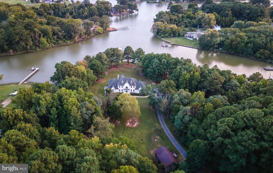 This private waterfront estate offers 1,200 feet of frontage on Saint Patricks Creek, set on over 18 acres with scenic woodland trails. The elegant Federal-style home boasts spacious rooms throughout, including a main-level master suite. The open floor plan maximizes water views, with abundant windows. The kitchen is well-appointed with an island, breakfast bar, gas cooktop, large pantry, wall oven, and warming drawer. The remodeled master bath features custom tilework in the shower, tub surround, and flooring.

The family room centers around a brick fireplace with a new Jotul wood-burning insert, while gas lines are pre-installed for future fireplaces in the master bedroom and living room. The office, with a bay window, overlooks the creek. Upstairs, two bedrooms each have an ensuite bathroom, accompanied by a game room.

Additional features include two newly installed geothermal HVAC systems with oil backup, providing three zones of climate control. The unfinished basement offers over 2,600 sq. ft. of potential living or storage space. Septic was upgraded in 2013.   A 48KW generator, 1,000-gallon buried propane tank in 2019, and ADT security system with cameras enhance security and convenience. The pier is equipped with water, electric, and a 40,000 lb lift & two slips.  Close proximity to several marinas. Perfect place for both relaxation and entertaining, with a versatile layout that suits any lifestyle.