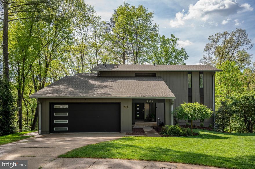 Tucked at the end of a quiet cul-de-sac in amenity-rich Lake Ridge, this fully renovated contemporary delivers the kind of privacy, scale, and modern design buyers rarely find together. Backing to serene woods, the home is perfectly positioned to enjoy peaceful views from two expansive decks—ideal for morning coffee, sunset dinners, or effortless indoor-outdoor entertaining.

Inside, soaring ceilings and a dramatic two-story fireplace anchor the light-filled great room, seamlessly connecting to a stunning, modern kitchen and open dining area. Thoughtfully designed with today’s lifestyle in mind, the main level features a spacious primary suite complete with custom storage and a private adjoining office—perfect for working from home without sacrificing comfort or style.

The walk-out lower level is built for entertaining, featuring a large wet bar, dedicated dining space, and an inviting recreation room ready for game days or gatherings. A private fourth bedroom with full bath offers flexible living—ideal for guests, in-laws, or even income potential.

Extensively updated in 2021 with a full renovation, plus a new roof, windows, and sliding doors, this home offers true peace of mind. Major systems have been taken care of, including a brand-new HVAC system and water heater in 2026.

Set within one of Northern Virginia’s most sought-after communities, residents of Lake Ridge enjoy access to pools, walking trails, sports courts, and more—creating a lifestyle that feels like a retreat while still being close to everything.

Refined, private, and move-in ready—this is contemporary living at its best.