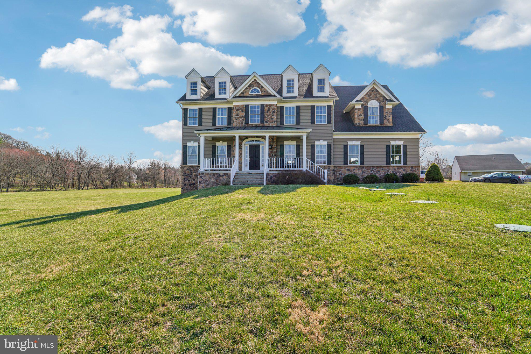 Come see this stately, CUSTOM built, 4 bedroom, 4.5 bath home set on over 5 acres in highly sought West Friendship in Howard County! As soon as you drive down the private driveway you'll love the stone accents on the front with the welcoming front porch and you'll notice that there is privacy ALL around! Come straight into the grand 2-story foyer and you'll notice the gleaming hardwood floors. To your right is the formal dining room with its lighted tray ceiling and chair and crown molding. To your left is the living room with more crown molding and both have floor-to-ceiling windows to let in all of the natural light. The family room has the coffered ceiling, recessed lighting and a stone gas fireplace for cozy nights at home. The Gourmet Kitchen is complete with 42" Cherry Cabinets, granite countertops, tiled backsplash, 20" ceramic tiled floor, stainless steel appliances and a great walk-in pantry! There is also a breakfast bar, great for a few barstools and plenty of room for a large kitchen table. Right off of the kitchen, you can exit out to the large maintenance free deck and overlook the massive lot and also take a dip into the above ground pool. The other door off of the kitchen takes you to the generously sized 3-car garage with plenty of storage. Next you can go up the dual-staircase to the 2nd floor where you will find 4 bedrooms and 3 full bathrooms. The primary bedroom is HUGE and has cathedral ceilings, ceiling fan, sitting area, 2 walk-in closets and an en-suite with a jetted tub, cherry cabinetry, double-vanity, oversized shower with custom tile, seamless glass enclosure and private water closet. Two of the other generously sized bedrooms have a Jack-and -Jill bathroom and the 4th bedroom has its own en-suite. The upper level also conveniently has the laundry room. The lower level is fully finished and is fantastic with its full sized bar with granite countertops, pendant lights, bar sink, built-in refrigerator too. There is also the 2nd family room with a door straight out to the large covered patio. There is also a large room that could be your home office, gym or could be used as a 5th bedroom, plus there is the 4th full bathroom in the lower level as well, so perfect for an in-law or au pair suite. Additionally on the property, is a well maintained 36 X 36 (1,296 square foot) out building equipped with water, electric and heat. It has approximately 400 square foot finished area. This multi-use building offers endless opportunities for the new owners. This building is being offered in "as-is" condition. All of this and Howard County Schools too. You will feel like you are out in the country, but you will be only minutes to 32, I-70, Rte. 40 and 97. More professional photos and 3D Matterport scan to come!