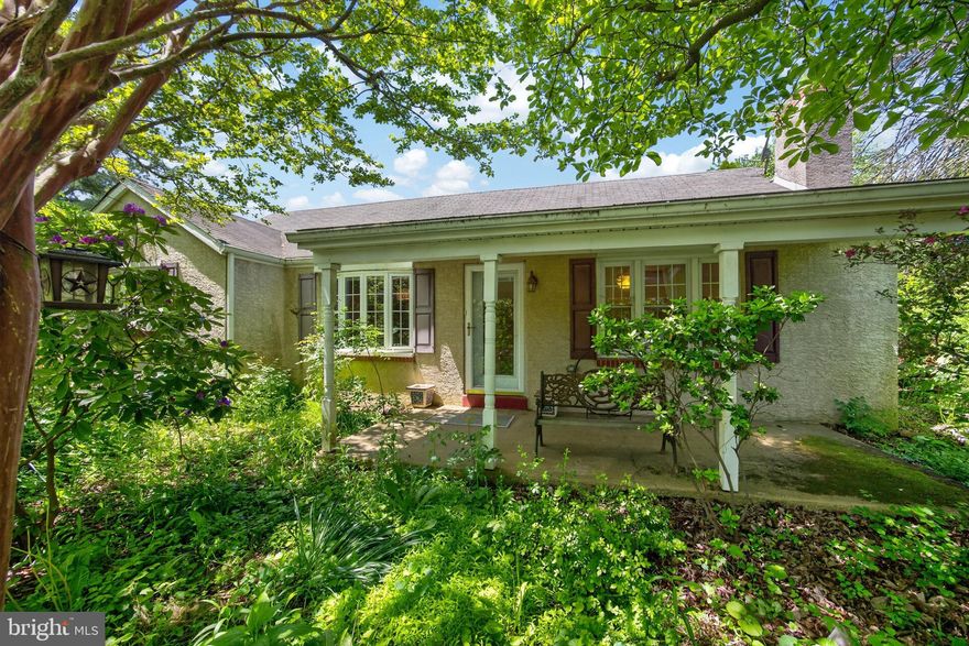 WEST CHESTER — A Rare Renovation Opportunity in a Premier Location. OPEN SAT. 5/16, 1-3 p.m. Set on a picturesque, level lot shaded by specimen trees, this single-level home sits squarely in the sought-after West Chester School District. Ideally located midway between West Chester and Malvern, you’re minutes from major transportation routes, the Exton and Malvern train stations, Philadelphia International Airport, the YMCA, ACAC, and scenic area parks. Nearby trendy dining spots and eclectic boutiques add area cachet.
A gracious front porch welcomes you home. Inside, a spacious living room centers on a handsome stone fireplace with wood stove insert. Hardwood floors (require refinishing) run throughout most of the home. The generous dining room flows into a well-appointed kitchen featuring granite countertops, a large island with casual dining bar, tile backsplash, wall ovens, refrigerator, and dishwasher. The primary bedroom offers two closets. The second bedroom features an en-suite half bath. A sizable full bath includes a shower and garden tub — ready for your personal renovation vision. The large, full basement offers laundry/ half bath, and exterior, bilco-style exterior access. An oversized detached garage and ample parking complete the package. In the rear yard, an expansive deck and secluded in-ground pool await a new owner’s renovation. If you have vision and the will to build equity, this is a compelling opportunity in a genuinely desirable location. Estate seeks "as is" sale. Contact us to see this home today!