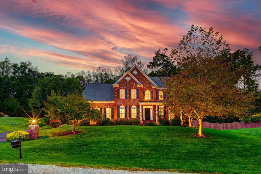 Set in a private, wooded setting in Lorton, this elegant colonial resides on nearly an acre of land and offers refined living with generous space, thoughtful upgrades, and a location that balances tranquility with everyday convenience. Backing to a protected wooded area and surrounded by mature landscaping, the home provides a peaceful retreat while remaining close to major commuter routes.

Inside, the home features five bedrooms and four-and-a-half bathrooms, complemented by newly refinished hardwood floors throughout the main living areas. The updated kitchen is both functional and striking, showcasing brand new quartzite countertops, double wall ovens, a cooktop, full pantry, and a large center island that anchors the space. A light-filled breakfast area overlooks the backyard, creating an inviting spot for casual meals and morning coffee.

The two-story family room impresses with soaring ceilings and a dramatic fireplace, offering an ideal setting for gathering and entertaining. A formal dining room adds classic charm, while a spacious main-level office provides the perfect work-from-home environment. The main-level primary suite offers convenience and comfort, complete with an ensuite bathroom featuring heated floors.

Upstairs, brand new carpet leads to generously sized bedrooms and an additional living area, offering flexibility for relaxation, play, or study. The freshly painted lower level expands the living space even further with a recreation room, full bathroom, and a full wet bar equipped with a refrigerator and dishwasher — ideal for hosting or extended living.

Additional highlights include new recessed lighting throughout, abundant storage space, and a three-car garage. Conveniently located near the VRE, I-95, and VA-123, this home delivers privacy, space, and accessibility in one exceptional offering.