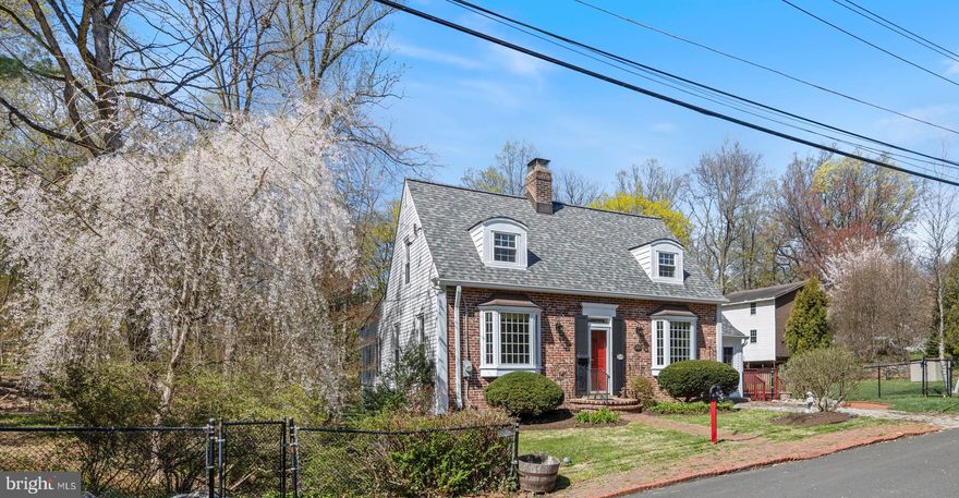 Constructed in the 1930’s during the height of the Great Depression, the lore is that this little brick Cape was a pattern plan from Better Homes & Gardens in the late 20’s called The Provincetown, modified slightly from the original design (brick fronted, different windows, dormers & an attached garage (now a playroom). Simply looking at the symmetrical façade, one would think that this house was small on the inside, you would be wrong! With nearly 2,000 Sq. Ft. of living space plus additional space in the walkout basement, there is much more than meets the eye. A brick sidewalk lines the entire front of a large yard for the neighborhood. There are heritage azaleas that line the side & rear yards, yet the large, level side yard has an abundance of sunshine. There are a series of metallic raised vegetable beds that could provide an abundance of food for the next owners. A large storage shed it located in the rear of the side yard. Located on the east side of the house is a small wooded area that has a brick patio & a semi-circular raised stone wall that is the perfect spot for enjoying a cocktail around a fire pit. The sounds of the spring-fed stream that meanders through the yard is a welcome reprieve from the grinds of daily life. Across the rear of the home is a spacious wrap around deck that allows for views into the neighboring woods. At the ground level, a large brick patio is accessible from the basement or a series of stepped retaining walls to the side yard. Approach the front entry down the brick pathway, there’s a delightful horse head newel post, boxwoods flanking the symmetrical bay windows & climbing roses. A Dutch door leads one to the living room on the left that has a wood burning fireplace, a wall of built-in bookcases & cabinets. The dining room on the right of the entry has an original corner cabinet. Both the living & dining rooms provide access to the amazing addition that was completed in 2019, nearly doubling the size of the first floor. Across the entire rear of the home, a vaulted great room was added with walls of windows overlooking the rear yard & a door to the deck. The modern kitchen is completely open to this new space with granite counters, maple cabinets, S/S appliances & a tiled floor. There is a large pantry on one side wall. Tucked off the side of the kitchen is the former garage that was converted to additional living space with another door to the outside deck. The washer & dryer are located within this room along with an updated powder room. Upstairs, there are three bedrooms & a hall bathroom. There is a surprising amount of hidden storage nooks & crannies tucked everywhere in most of the roof eaves. There is access to the attic from one of the large closets in the primary bedroom. The bedroom located over the former garage has two unique windows, portholes actually! In the basement, there is another large family room with a second decorative fireplace & a window overlooking the side yard with Mercer tiles inset into the windowsill. The second full bathroom is actually located off this space. When the addition was added along the entire rear of the home in 2019, the area in the basement was also finished as a large game room (the pool table conveys with the sale!) with an epoxy floor & a door to the rear patio. For those that know Wyncote, it is an amazing walking community, with sidewalks on most of the streets & five township owned parks in the community. The Jenkintown/Wyncote SEPTA station provides the best service to Temple University, downtown Philadelphia, 30th Street Station, the universities & hospitals of Drexel & University of Pennsylvania & even the airport. Just 5 minutes away, one will find many locally-owned businesses in downtown Glenside or Jenkintown for dining, shopping and other service needs. Just 10 minutes away, one can find a Trader Joe’s and Whole Foods market in Jenkintown, and other grocery outlets are easily reached.