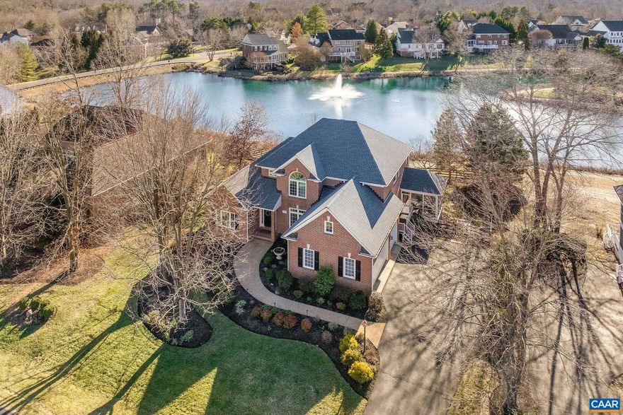 Elegant All-Brick Home Overlooking Glen Lochan Pond in Glenmore. This beautifully designed four-bedroom home, featuring two primary suites, is nestled along the serene Glen Lochan Pond in the highly sought-after Glenmore community. Upon entering, you will be welcomed by a sunlit, two-story living area with expansive windows offering stunning views of the water and its charming fountain. The open and spacious floor plan seamlessly connects to a screened-in porch and deck, providing the perfect setting to enjoy the scenic surroundings. The main-level primary suite allows for easy one-level living, while the second primary suite upstairs, along with an additional bedroom featuring an en suite bathroom, ensures ample space and privacy for family and guests. The walkout basement offers a versatile open space, ready to be tailored to your needs. It also includes a bedroom and full bath, making it ideal for extended stays or additional living space. Conveniently located near walking trails and just a short distance from the the Club at Glenmore, this property offers both tranquility and accessibility. As an added benefit, the purchase of this home includes a 25% discount on the initiation fee for the Club at Glenmore.,Fireplace in Family Room