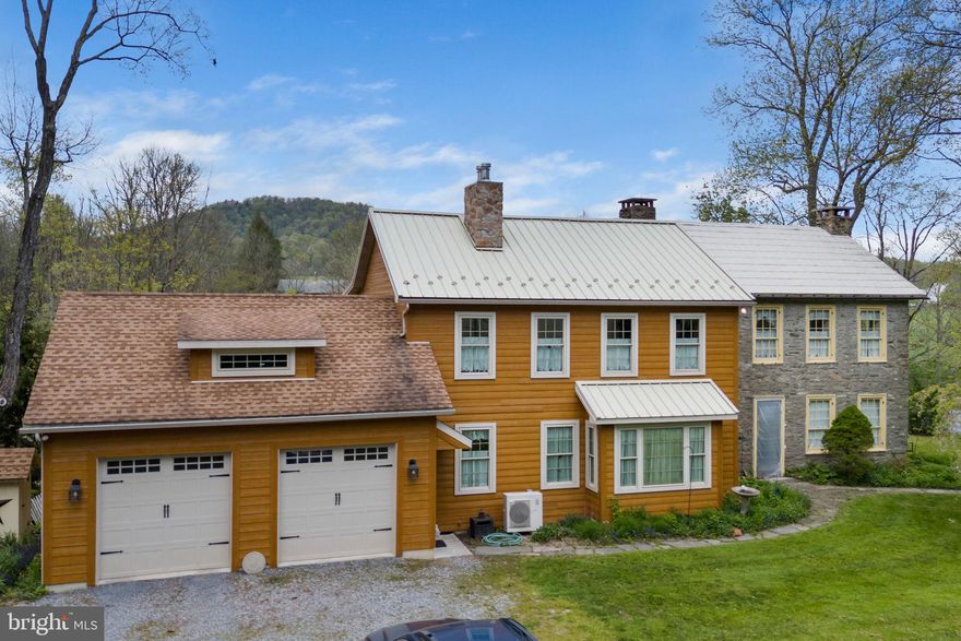 Well loved  by long standing owners , this historic 1780's era Pa stone farmhouse homestead has a perfect balance of old world charm seamlessly blended with all  the necessary modern amenities.  Two parcels totalling 14+ acres complete with a two story barn and picturesque views in every direction from either of the two covered porches on the main level and  a bonus second story porch.  Attention to the details are evident with pointed stone walls, durable white oak flooring flowing throughout and cut stone wood burning fireplaces.  The living room has a stone fireplace  and the foyer has a second stone fireplace. adding character and supplemental heat.  The kitchen is adorned with  pine cabinetry harvested from the property, tiles imported from Holland and a restored late 1800's wood burning cook stove. Highly desirable open concept layout from kitchen to dining area provides access to one of the two  Trex deck porches on the main level.  First floor has a  full bath with a  curb less shower and convenient stackable washer & dryer.  There is a mudroom with it's own  enamelled cast iron  sick for extra use.  The home has 2 stair cases, 1 being a pie staircase in the original portion of the house and the second being in the Addition that was completed in 2016.   Three bedrooms and a full bath  with bidet ,  tile flooring and walk in closet are all located on the second floor. As well as the art studio with  vaulted ceilings, office area and access to second story porch. So many opportunities to garden,  expand flower beds, play with the family/friends in the creek and enjoy the quiet peaceful setting of this historic home.  Home also has an attached over sized 2 car garage.   Schedule your showing today