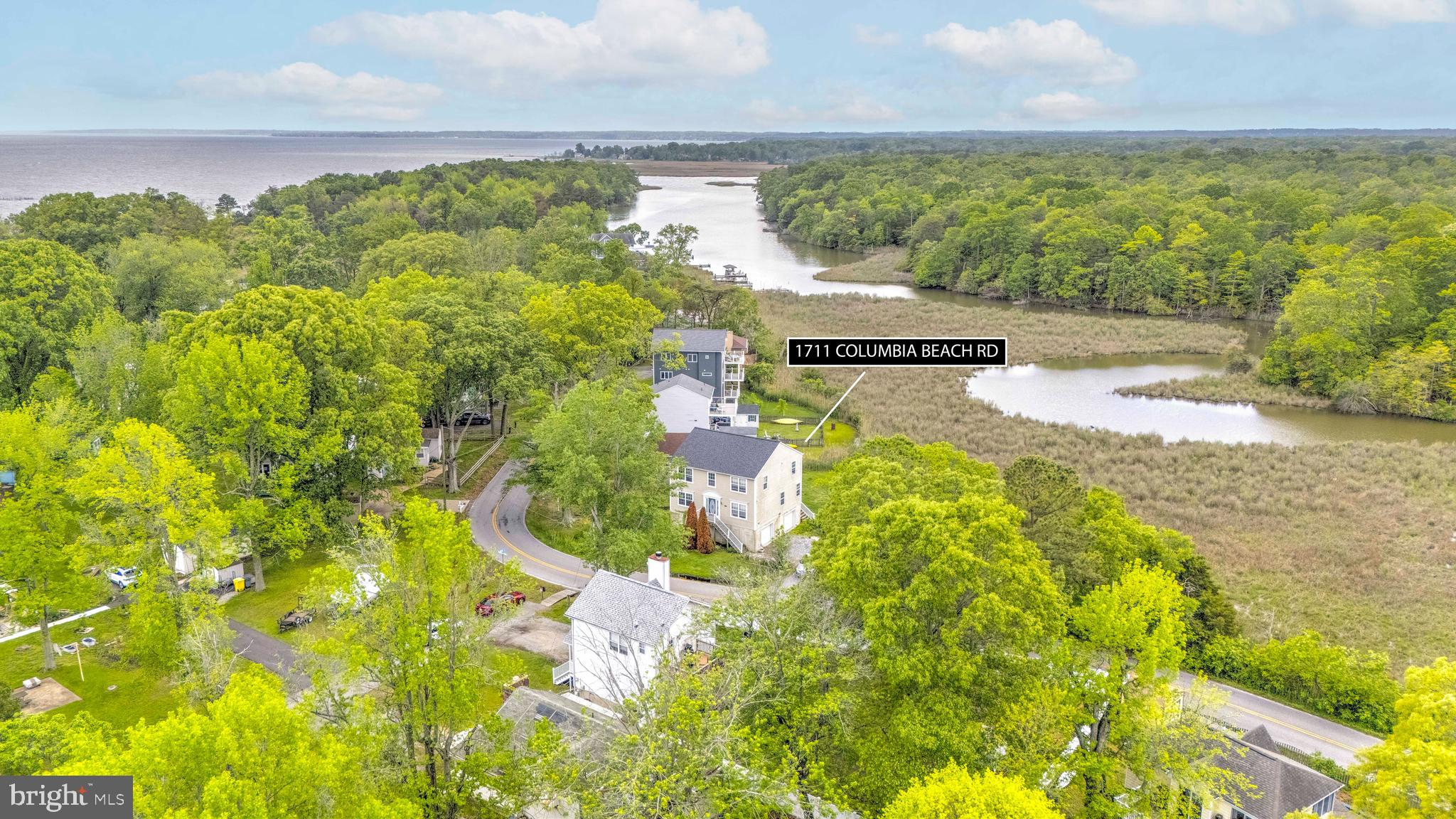 Nestled between serene waters, this home offers stunning, unobstructed views of Flag Pond from the rear and views of the Chesapeake Bay from the front. Enjoy watching local waterfowl and soaking in the natural beauty from every angle. Inside, the spacious kitchen opens to the family room, perfect for gathering, along with a formal living room and a main-level office or potential 5th bedroom. Upstairs features four bedrooms, including a primary suite with views of both the Bay and Flag Pond, plus an en-suite bath, three additional bedrooms, and a full hall bath. A two-car garage includes an extra storage room. While the home could use some updating and TLC, it presents a fantastic opportunity to make it your own. Located in a vibrant waterfront community with amenities such as a boat ramp, pier, tennis courts, and more. Come experience the Chesapeake Bay lifestyle.
