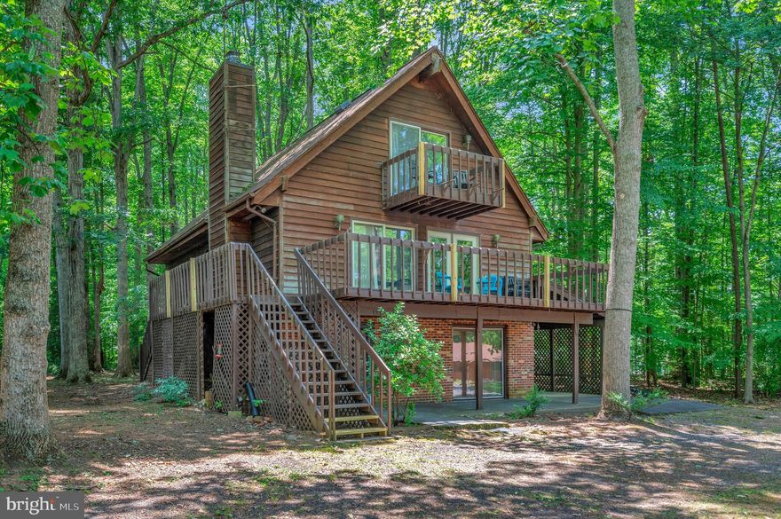 Location-Location-Location is what it's all about.  Madison Circle is a  waterfront street with an awesome & impressive variety of homes. This charming multi-level 4 Bedroom 3 Bath rustic contemporary home sits across the street from the lake & enjoys its views from main level & upper decks.  The sliding glass doors let in the natural light  &  view of  the woods & water. There is a wrap around  main level deck; a patio  off the lower level family room & carport plus  a  private platform deck between the shed & home.  proane heater in fam room conveys. There are several attic storage nooks off the bedrooms-all have doors for access.  Needed: lots of TLC & updating though the main level bath was renovated a few years ago. Lots of space, surprising nooks & crannies including a cedar closet under the first stairwell. Seller has never lived in the home though their family were full time  & long-term occupants of the community. For this reason the property is being conveyed as it sits. Do not forget to scope out the 12 x 16 lighted workshop shed nor the walk in storage & cabinets behind the carport.