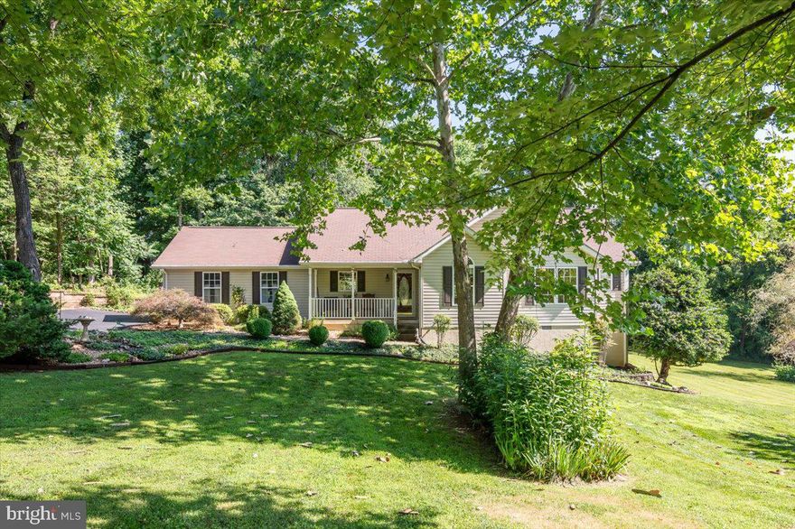 This extraordinary Rambler sits on a beautifully landscaped and manicured 1.44 acre lot bordered by huge mature trees.  It's in a lovely subdivision of approximately 20 homes, all very well kept, friendly, quiet and safe.  The setting is that of a gem in the edge of the Blue Ridge Mountains.  As you turn into the freshly paved and sealed asphalt drive, you'll note that the lot is festooned with sculpted trees, flowers, rock gardens, retaining wall, and  many lovely shrubs including a stunning Japanese Maple greeting you on arrival as you head toward the front porch.  The porch is a southern-style shaded one where "sitting a spell" will become part of your regimen!  Gleaming hardwood floors adorn the foyer, great room, kitchen and dining areas as well as the hallway.  The ceiling is vaulted in this main living area and gives a feeling of spaciousness and openness.  The floors reflect the light! There are no window coverings throughout most of the the home.  It's so private and surrounded by such natural beauty that none are needed and each window offers a uniquely lovely view.   The kitchen is highly functional with upgraded laminate tops, stained glass light fixtures, a natural stone backsplash, and a glass topped electric range with a range hood and exhaust.  There's ample cabinetry and a large pantry for provisions.  All areas of the home are freshly painted in tasteful colors.  The great room is warmed by a gas fireplace with decorative mantel and ventilated by a ceiling fan.  An owned underground tank serves the fireplace and the whole-house generator - grid goes down, you don't.  An exceptionally accommodating screened in porch overlooks the back yard, again ventilated with its own ceiling fan.  The one-car garage off the kitchen is insulated and the floor is painted.  Down the hallway, washer and dryer are closeted in their own convenient laundry room.  The primary bedroom and the two large secondary bedrooms are carpeted with upgraded Berber carpet and cooled by ceiling fans.  Primary and one of the secondary bedrooms have walk-in closets.  The ceiling in the primary bedroom is vaulted, the room is light-filled, and overlooks the gorgeous back yard.  The primary bathroom has ceramic-topped dual vanities and an awesome upgraded tiled shower with a frameless door.  The secondary hall bath has a tub shower.  The natural slope allows for a wonderful storage area in a 20-foot crawl space.  You'll notice that floor insulation underneath is thoughtfully upgraded.  A whole-house water filter draws from a deep drilled well.  Crawl space also has a built-in deck for tools and work bench (approximately 10' X10', a sump pump, insulation with a vent for AC/Heat.)  Shopping, medical facilities, cultural attractions like The Library of Congress and Packard Theatre are 7 miles away in Culpeper.  Historic Orange is 7 miles the other way, and Gordonsville 7 miles from there.  Commuting to NOVA is a snap with easy access to Highway 29.  D.C, Charlottesville and Richmond are an hour or two away, depending on traffic.  Truly love your life here in Rapidan. Welcome home!