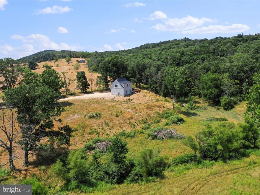 JUST TWO HOURS FROM WASHINGTON D.C., THERE IS A WV MOUNTAIN GETAWAY WITH PRIVATE ACREAGE, MOUNTAIN VIEWS, PASTURES AND WOODS. THE UNRESTRICTED PROPERTY BOASTS THE SOUGHT AFTER COMBINATION OF LEVEL PASTURES, A HOME BUILT IN 2023 WITH A LOWER LEVEL THREE CAR GARAGE PERCHED ON A HILLTOP WITH A VIEW AND WOODS FOR PRIVACY AND RECREATION. THERE IS A POSSIBILITY FOR FUTURE OWNERS TO BUILD ON THE CLEARED LAND NEXT TO THE NEW STRUCTURE. THERE IS PLENTY OF ROOM TO HUNT, EXPLORE AND RIDE ON ATV'S. THERE IS A STREAM THAT RUNS THROUGH THE PROPERTY. THE OVER-SIZED GARAGE HAS THREE BAYS, HIGH END GARAGE DOORS AND OPENERS, INSULATED, DRYWALL, CONCRETE FLOORS, A WORKSHOP AREA AND A HALF-BATH. ON THE SECOND LEVEL IS THE LIVING AREA WITH TALL 10' CEILINGS, OPEN CONCEPT LIVING, TALL WINDOWS TO LET IN THE NATURAL SUNLIGHT AND SHOW THE IDYLLIC VIEWS, A CUSTOM BUILT KITCHEN WITH STONE COUNTER TOPS, LARGE KITCHEN ISLAND WITH SEATING, LAUNDRY/MUDROOM, HALLWAY FULL BATHROOM, GUEST BEDROOM, SIZABLE FOOD PANTRY,  MASTER BEDROOM WITH ATTACHED MASTER BATHROOM AND SUBSTANTIAL WALK-IN CLOSET WITH FLOOR TO CEILING STORAGE. COME AND SEE THIS WV MOUNTAIN GET-AWAY FOR VACATION OR FULL-TIME RESIDENCE!