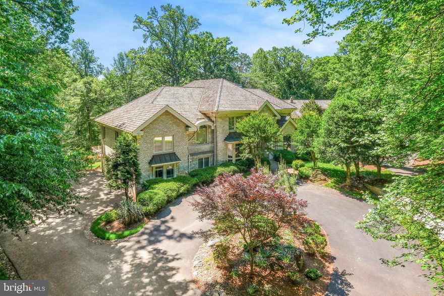 Nestled on a private, picturesque 2.8-acre lot, this custom contemporary residence by renowned builder J.P. Kollar offers over 8,000 square feet of light-filled living space. Thoughtfully crafted for those who value serenity, natural beauty, and sophisticated entertaining, the home provides a seamless commute to Maryland, Washington, D.C., and Northern Virginia. Designed to accommodate multi-generational living and gracious hospitality, the residence features 7 bedrooms, 6 full baths, and 3 half baths. A luxurious owner’s suite enjoys its own private level, offering a tranquil retreat within the home. Architectural highlights include a dramatic central atrium, expansive windows capturing sweeping views, and a gorgeous verdant lawn. The rear of the property reveals a stunning grove of trees that gently slopes away, enhancing both privacy and visual appeal. Smart home features include a comprehensive security setup with cameras and exterior lighting, and a three-car garage equipped with an electric vehicle charger. These modern upgrades complement the timeless sophistication of the residence. A long, elegant drive leads to a stately brick facade, setting the tone for the impeccable interiors. Inside, the floor plan flows effortlessly from one space to the next, with soaring ceilings and abundant natural light streaming through large windows and skylights. A dramatic two-story entry with new ceramic tile opens to generous living and dining areas, while the magnificent great room—featuring curved architectural walls and a stylish wet bar—anchors the rear of the home with panoramic views of the grounds. The chef’s kitchen, complete with a new Quartz center island and adjoining breakfast room, is bathed in natural light and opens to an expansive deck—ideal for al fresco dining and outdoor gatherings. The fully finished, walk-out lower level is designed for leisure and comfort, offering a spacious recreation area, dual-sided fireplace, full bar, seventh bedroom, and additional full bath. Superior craftsmanship is evident throughout, with bespoke details such as Brazilian cherry hardwood flooring, solid maple interior doors, handcrafted railings, custom beams, low-voltage recessed lighting, and three fireplaces. Recent updates include a new cedar shake roof, new skylights and gutters, and modernized HVAC systems with three-zone climate control. Meticulously maintained and continuously updated by its original owners, the home is in impeccable condition.

Ownership includes access to this exclusive community and offers a blend of luxury and lifestyle, featuring a golf course, tennis and swim clubs, an equestrian center, scenic trails, and beautifully maintained parks. Just minutes away, Avenel Local Park provides abundant recreational opportunities, including soccer fields, tennis courts, basketball courts, baseball diamonds, and bike trails. Residents enjoy proximity to a wide array of entertainment, dining, and shopping options, including Market on Boulevard, Potomac Village Center, and the cultural attractions of Glen Echo Park. Convenient commuter routes such as Route 190, I-495, I-270, and Cabin John Parkway provide easy access to Washington, D.C., and the surrounding region. Nature enthusiasts will appreciate the nearby Great Falls National Park and the C&O Canal, ideal for hiking, biking, and outdoor escapes. The community also offers access to the Tournament Players Club Golf Course and the Avenel Swim & Tennis Club. Additional amenities include private security patrols, professional snow removal, and meticulously landscaped common areas, ensuring a well-maintained and secure environment.