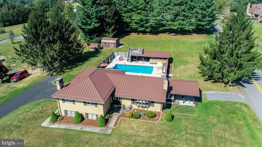 This charming traditional home in the desirable West Oakland area offers a perfect blend of comfort and style, while being close to schools and the hospital.  With 4 spacious bedrooms and 2.5 bathrooms including a large primary suite, the layout is designed for both relaxation and entertaining. The inviting living area features a cozy brick fireplace, creating a warm ambiance for gatherings. The fully finished basement provides additional living space with convenient garage access. Step outside to enjoy your own personal oasis, complete with a fenced in-ground pool, kitchenette pool house, and a lovely roof deck that boasts stunning mountain views. The expansive lot of nearly an acre offers plenty of room for outdoor activities and gardening. Additional highlights include hardwood and carpeted flooring throughout, a traditional floor plan, and multiple patios and porches for enjoying the serene surroundings. With ample parking, including a driveway and attached garage, this home is ready to welcome you. Experience the perfect blend of indoor comfort and outdoor beauty in this exceptional property!