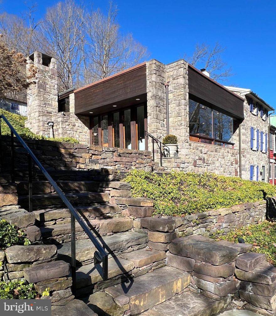 An architectural prodigy, this mid-century modern jewel is characterized by its stunning glass and stone walls, offering breathtaking creek views. Ready for immediate occupancy and semi-furnished, the residence has undergone recent enhancements including radiant heated flooring, an updated floor to ceiling marble fireplace in the primary bedroom, wine cellar and renovated bathrooms.  The dwelling consists of two bedrooms, supplemented by an additional "Murphy" bedroom, offering a therapeutic and convenient environment. The Lumberville General Store and the historic Black Bass Inn are within walking distance. The residence functions as a sanctuary, equipped with all the contemporary, high-end comforts you could wish for. The professional-grade kitchen comes complete with a Viking range stove, a Miele dishwasher, an island bar and  flat screen television. All of the stone fireplaces have been fitted with new gas inserts, and all rooms have been freshly painted, inclusive of Sonos sound system and Hue color-changing enhanced lighting. This exceptional rental property, with its impressive allure,  is certainly an opportunity not to be overlooked!