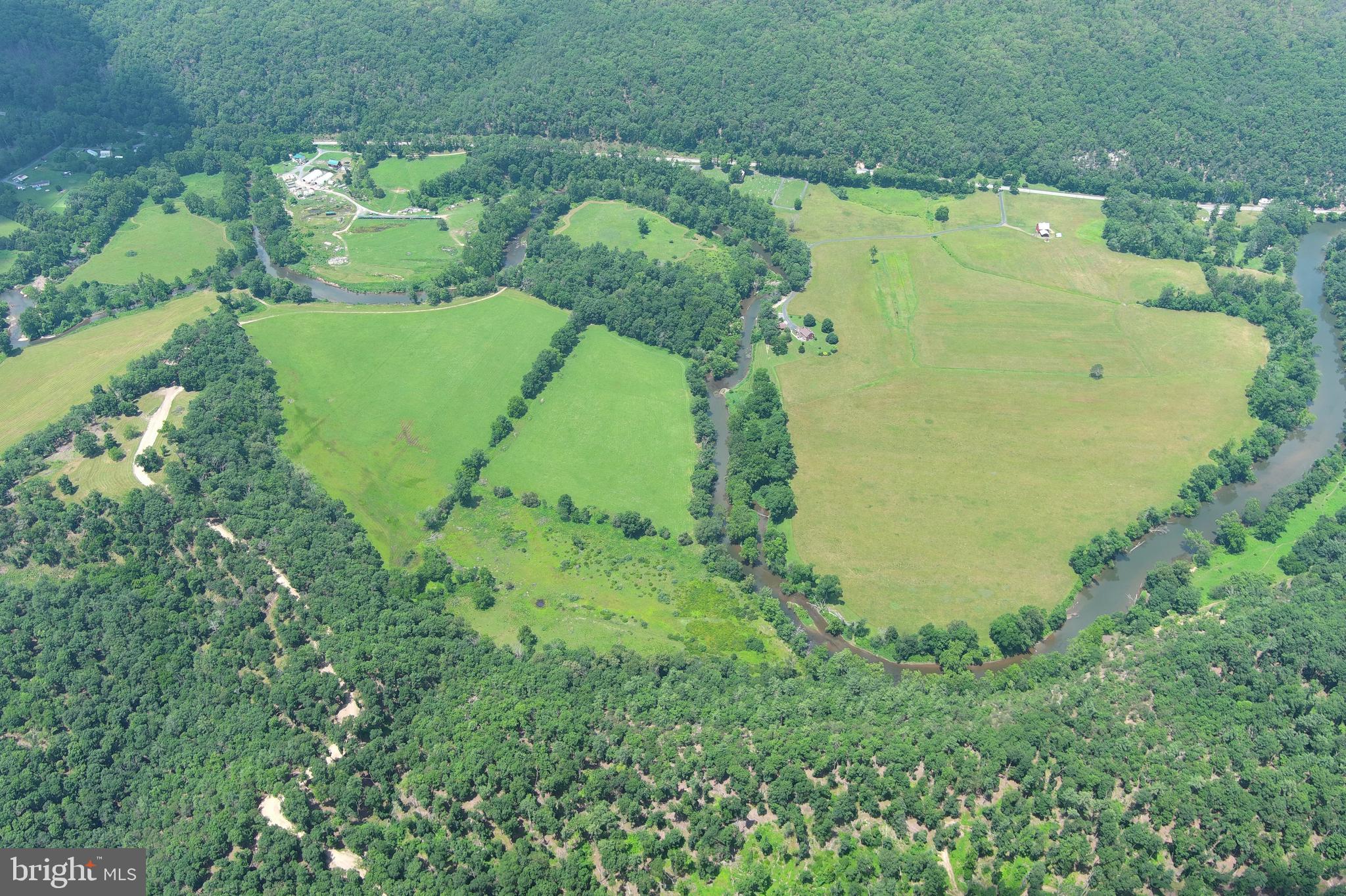 ALMOST A MILE....109 PRISTINE ACRES WITH ALMOST A MILE OF FRONTAGE ON WV'S CLEANEST RIVER "THE CACAPON" 4852 FT TO BE EXACT. 35 ACRES OF PICTURE PERFECT RIVER BOTTOM HAYFIELD, 7 ACRE PASTURE/FOOD PLOT IN THE BEND OF THE RIVER AND ANOTHER 10 ACRES OF PASTURE GENTLY SLOPING UP THE MOUNTAIN......APPROX 52 ACRES OF OPEN LAND, SUITABLE FOR CROPS AND ANY TYPE OF LIVESTOCK. THE RIVER FRONTAGE IS STUNNING, EASILY ACCESSIBLE AND DIVERSE....DEEP POOLS, RUNS & RIFFLES....FISH FOR TROPHY SMALLMOUTH BASS, PARK YOUR CAMP CHAIR IN THE RIVER WITH YOUR FAVORITE BEVERAGE OR DROP IN YOUR KAYAK OR TUBE AND FLOAT DOWNSTREAM TO A PUBLIC ACCESS POINT. THE HUNTING? PHENOMENAL....THE ENTIRE PROPERTY IS JUST A HUGE FOOD & WATER SOURCE FOR GAME, ANY CRITTER YOU WISH TO CHASE CAN BE FOUND HERE. LONG RANGE SHOOTER? 500+ YARD SHOTS CAN BE ACHIEVED AT THIS LOCATION. BASICALLY THE ENTIRE RIVER BOTTOM IS IN THE FLOOD ZONE, WHICH IS COMMON ON ANY SIZABLE RIVER. SO, WHERE DO YOU BUILD? ON THE RIDGE....ELEVATED RIDGE TOP BUILDING SITE OVERLOOKS YOUR PASTURE & RIVER....A TOP NOTCH BUILD SITE THAT CAN ACCOMMODATE ANY SIZE HOME. PARADISE FOUND ONLY 1.5 MILES OFF THE PAVED ROAD.....LESS THAN 15 MINUTES FROM THE THRIVING VILLAGE OF WARDENSVILLE, 35 MINUTES FROM WINCHESTER, VA AND 110 MILES FROM THE WHITE HOUSE! EASY TO GET TO BUT HARD TO FIND, THE DRIVE FROM DC BELTWAY IS A BREEZE. NO HOA AND MINIMAL DEED RESTRICTIONS. IF THIS PROPERTY DOESN'T CHECK EVERY BOX ON YOUR LIST, THEN YOU'D BETTER MAKE A NEW LIST. WOODS, WATER, FIELDS & VIEWS AND YOU CAN DRIVE AROUND MOST OF THE PROPERTY IN A CAR. IF YOU CAN'T PULL THE TRIGGER ON THIS ONE, STOP LOOKING, YOU'RE NOT A BUYER.
