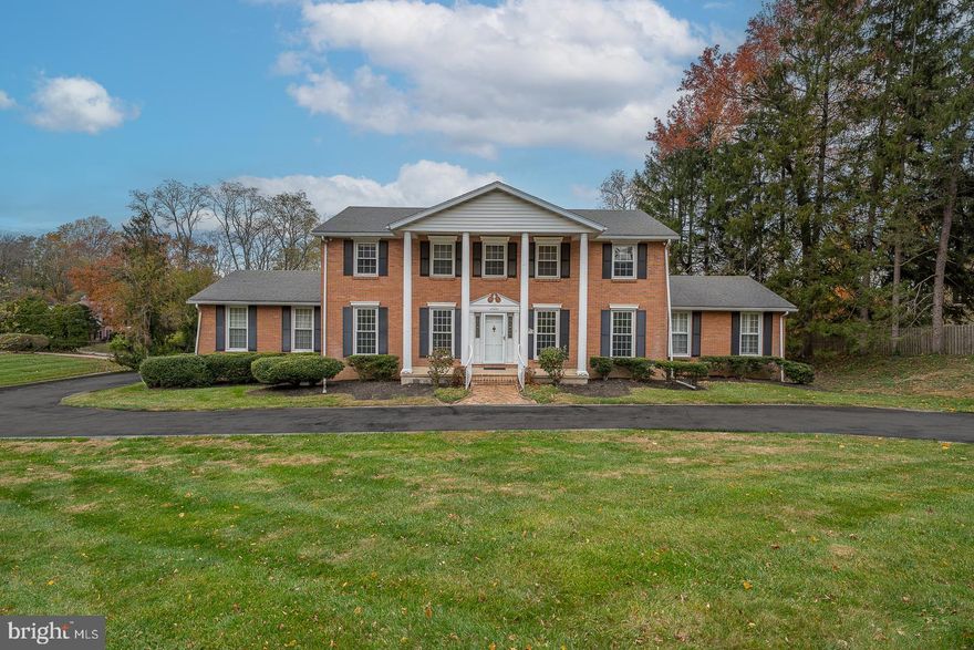 Welcome to this stately and spacious residence nestled on a beautifully landscaped 0.83-acre lot in one of Gladwyne’s most desirable neighborhoods. Offering 6 bedrooms, 4 full bathrooms, and 1 half bathroom, this home combines classic charm with modern comfort in the award-winning Lower Merion School District. A circular driveway leads to the stately front entrance, framed by timeless two-story pillars. The center hall opens to a grand formal living room featuring detailed crown molding and a double-sided gas fireplace, which also warms the covered rear porch—perfect for relaxing or entertaining. The sun-filled formal dining room with hardwood floors and built-in cabinetry sits conveniently adjacent to the kitchen for seamless entertaining. The kitchen boasts stainless steel appliances, a breakfast bar, and opens to a bright family/sunroom enhanced by skylights and sliding glass doors overlooking the tranquil backyard. The main-floor primary suite features a spacious walk-in closet with laundry and a full ensuite bath. Upstairs, a second primary suite includes its own walk-in closet and private bathroom. Three additional bedrooms with generous closets and a full hall bath with laundry complete the upper level. The finished walkout lower level offers additional living space, including a bedroom with ensuite bath and walk-in closet—ideal for guests or an au pair suite—along with a large recreation room with gas fireplace and access to the back patio and yard. Additional highlights include an oversized two-car garage, lush landscaping, and an unbeatable location close to the Philadelphia Country Club, major roadways, and all the dining and shopping in Gladwyne and nearby Conshohocken.