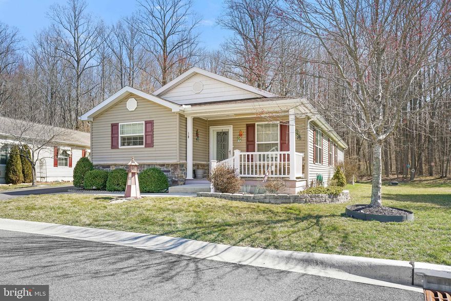 This lovely home  with 1 car attached garage . 2 or possible 3 bedroom 2 full bath home is in a 55+ community called Cecil Woods.  The house shows beautifully.  . Exterior features  a covered porch and a rear deck to enjoy the  outside.   The living room is spacious, with lots of light . The kitchen area is gorgeous  with hard wood flooring, a huge center island , upgraded  cabinets,  pendent and recessed lighting are some of the features. The master suite features a spacious walk-in closet, ceiling fan and a large master bath with a double vanity, and  walk in  shower, and an extra vanity for even more space!   The additional bedrooms is a great size too!  There is even  a possible third bedroom  if needed it  is currently being used as a den. The full hall bath includes a tub/shower combo. There is a large laundry room that  leads to the one car garage and the rear deck off the back of the house . The house backs trees with a  view of the woods , The Cecil Woods community has many amenities, including walking paths,  a community center with a clubhouse, a library, and exercise room .  Call today !